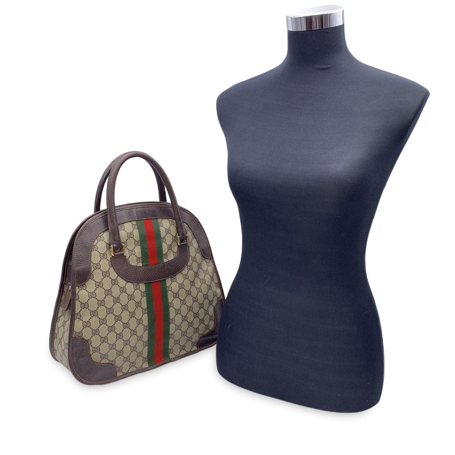 Beautiful Gucci handbag made in beige monogram canvas with brown leather trim and handles. Green/Red/Green stripes on the front and on the back. Upper zipper closure. Beige lining. 1 side zip pocket inside. 'Made in Italy by Gucci - Brevettato' tag