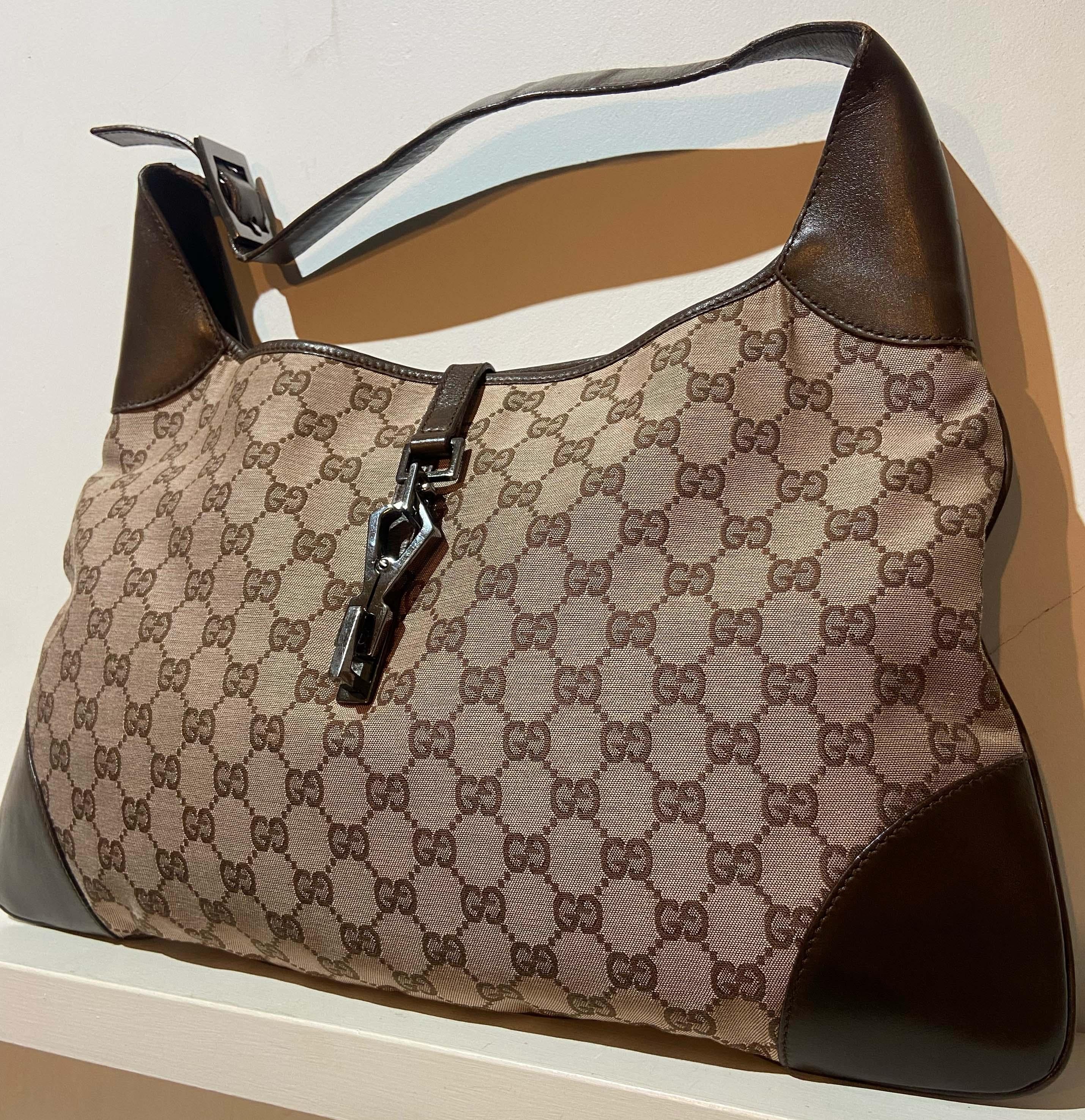 Vintage Gucci Jackie shoulder bag. Features the classic brown GG Monogram logo all over. Brown leather adjustable handle, back interior zip pocket and fastens with front clip silver hardware.  In excellent vintage condition. 

Brand: Gucci
Color: