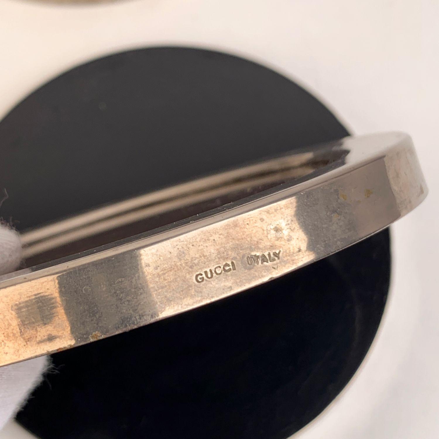 Set di 4 sottobicchieri tondi Monogram di Gucci. Bordo in metallo argentato e tela marrone con monogramma GG - Gucci sotto un vetro. Fondo in lucite nera. 'Gucci - Italia' inciso sul lato di ogni sottobicchiere. Diametro: 4,5 pollici - 11,5