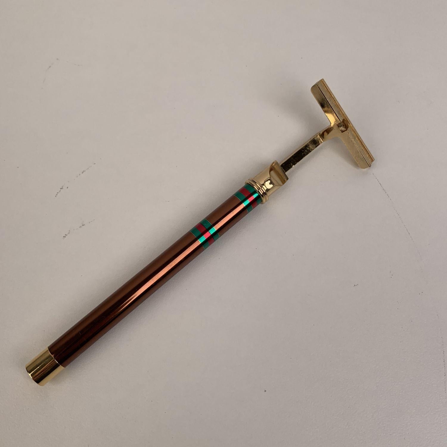 Vintage GUCCI razor for shaving in the original gift box. Gold metal with brown handle and green/red/green detailing. GG logo at the base. Marked 'Gucci - Firenze' on the side. Height: 6.1 inches - 16 cm . Width: 1.5 inch - 4cm. Period / Era: ca