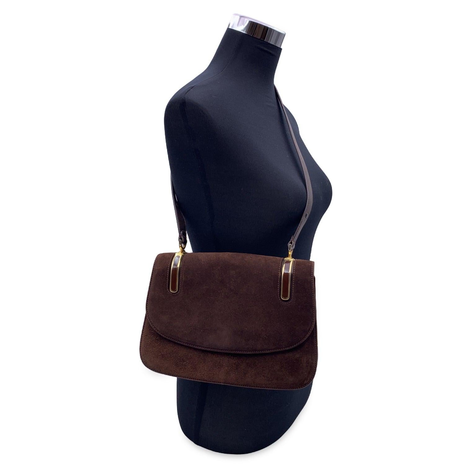 Beautiful vintage Gucci shoulder bag made in brown suede. gold metal detailing on top with brown enamel. Flap with button closure. Adjustable leather shoulder strap. Brown leather lining. 1 side zip pocket and 2 side open pockets inside. 'GUCCI
