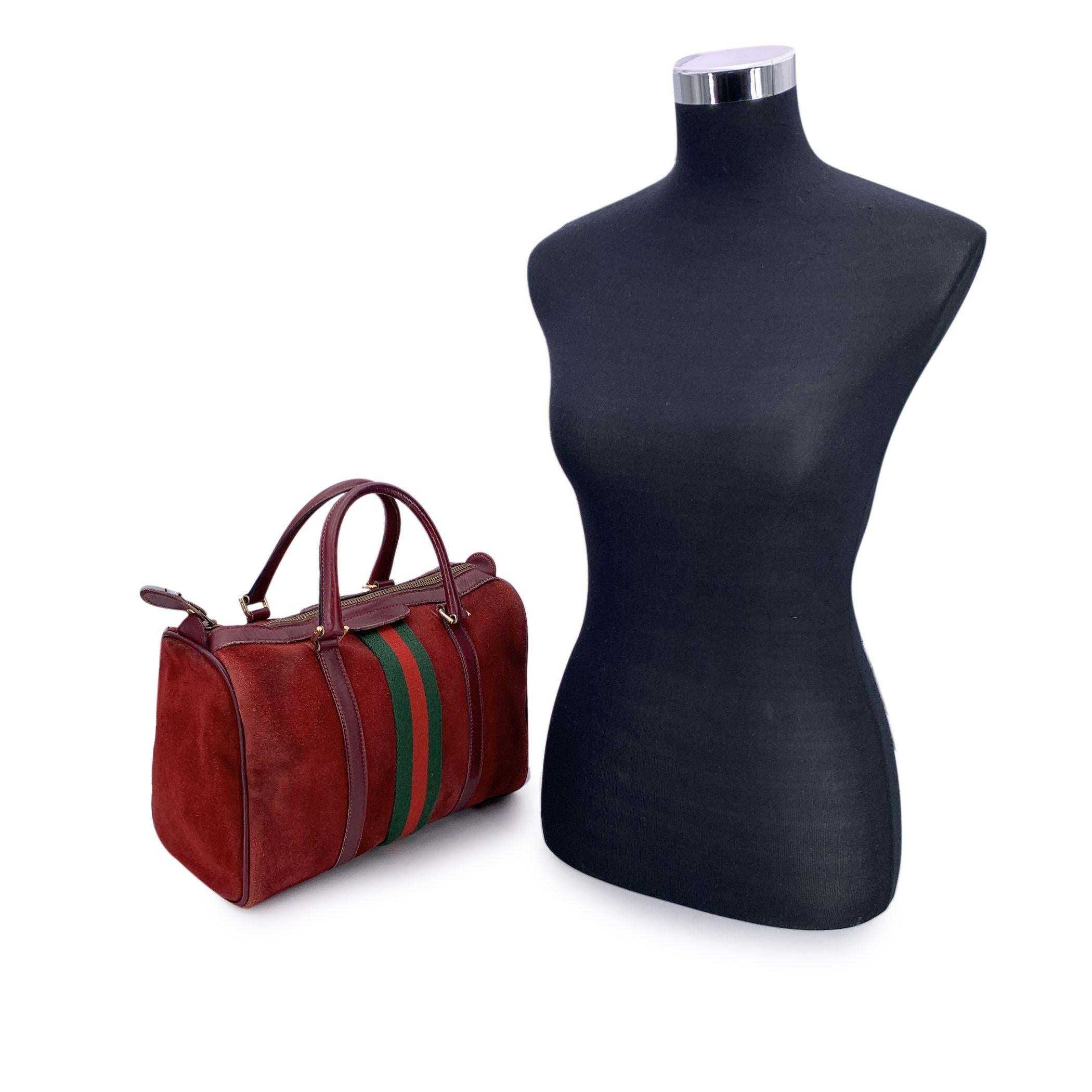 This beautiful Gucci Boston Bag is a timeless classic that effortlessly blends style with practicality. Crafted from burgundy suede and leather, the bag is accented with burgundy leather trim and handles, creating a refined and elegant look. The