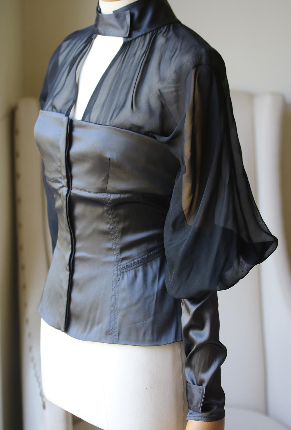 A gorgeous black and grey stretch silk top from Tom Ford for Gucci circa 2003. The bodice has a stitched strapless satin bodice with sheer chest and upper back panels with a high collar. The semi-sheer dramatic sleeves. The neckline and zippered