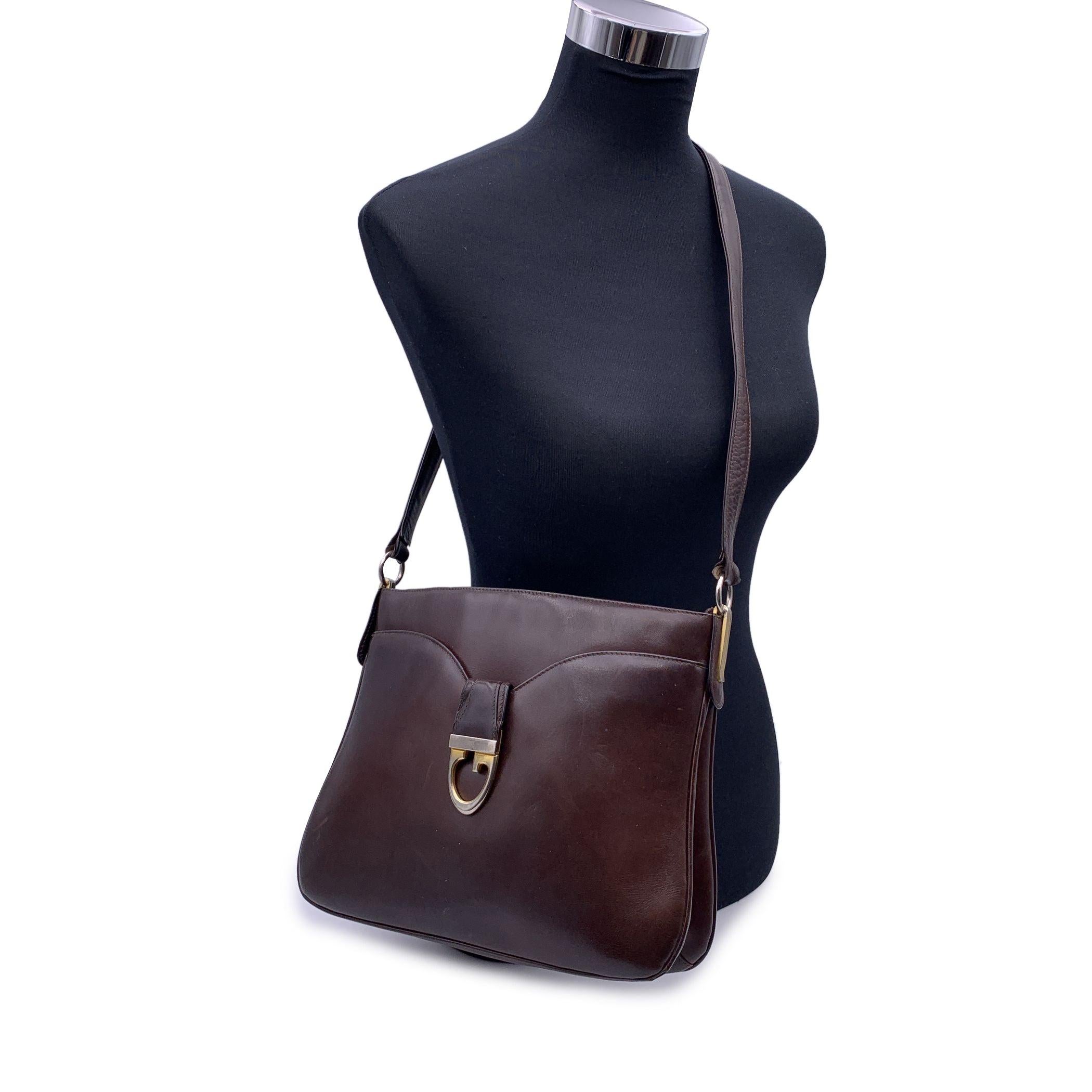 Beautiful Gucci shoulder bag, crafted in dark brown leather. Gold metal hardware. 1 front pocket. 2 main sections with 1 middle zip section. Brown leather lining. Adjustable shoulder strap in 2 lenght. 'Made in Italy by Gucci' embossed inside