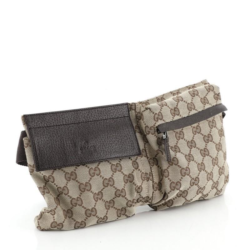 This Gucci Vintage Double Belt Bag GG Canvas, crafted in brown GG canvas, features an adjustable textile strap, front zip and snap pockets, and gunmetal-tone hardware. Its zip closure opens to a brown fabric interior. 

Condition: Excellent. Minor