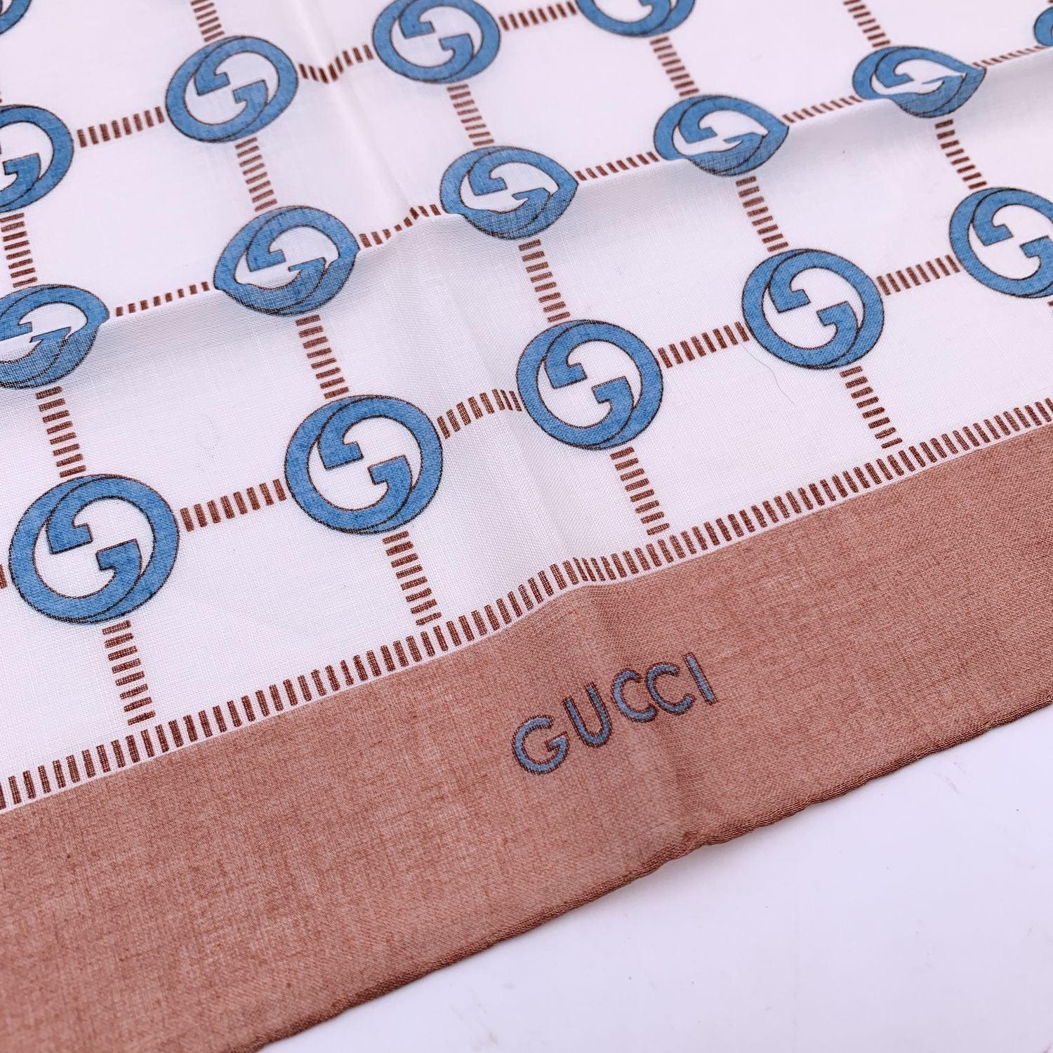 Vintage neck scarf by GUCCI. 100% Cotton. Light blue GG logo pattern with light brown borders. 'Gucci' signature printed on the lower center border. Approx. Measurements: 16.5 x 16.5 inches - 42 x 42 cm Details MATERIAL: Cotton COLOR: Brown MODEL: