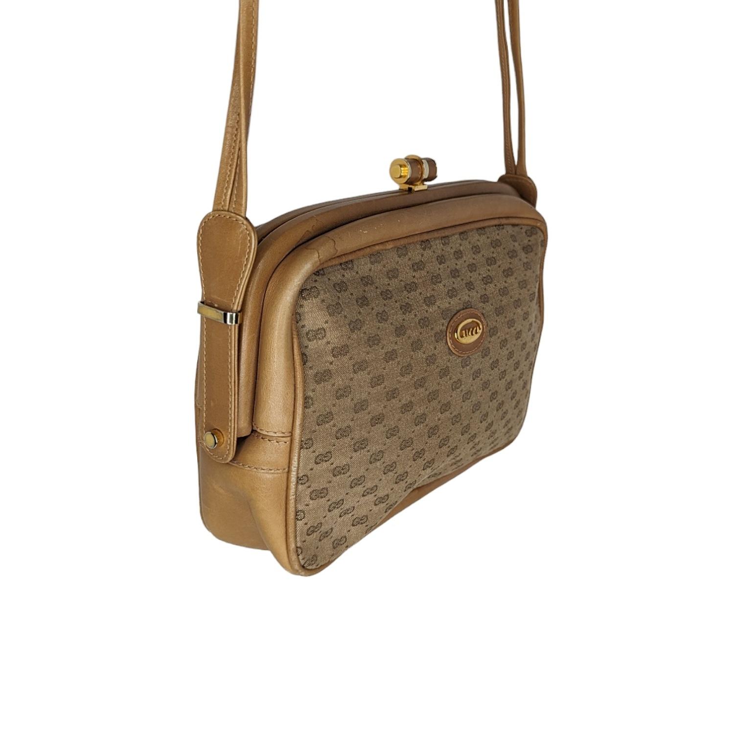 Ce sac à bandoulière vintage de Gucci est réalisé en toile micro-monogramme GG, de forme rectangulaire, avec des bordures en cuir PVC, des accents en métal doré, un fermoir à ressort avec un cadre recouvert de cuir, un intérieur doublé de cuir lisse