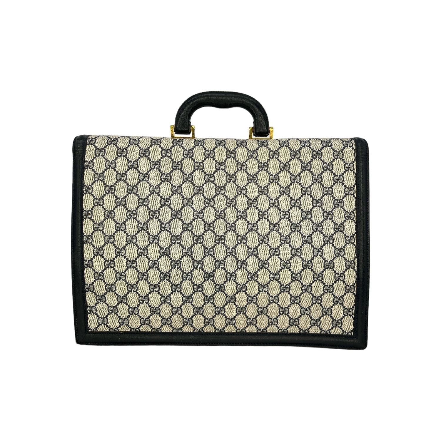 This Gucci GG Plus Navy Blue Briefcase Portfolio was made in Italy and it is finely crafted of the classic GG Supreme canvas exterior with leather trimming and gold-tone hardware features. It has a leather top handle. It has a push-lock closure that