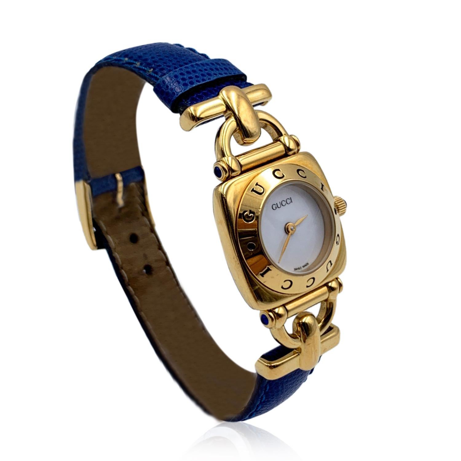 Gucci 6300 L Gold plated stainless steel wrist watch from the 90s. White dial and Sapphire crystal. Swiss Made Quartz movement. Gucci written on face and on the bezel .Water Resistant. Blue leather trap with buckle closure (GG logo engraved on the