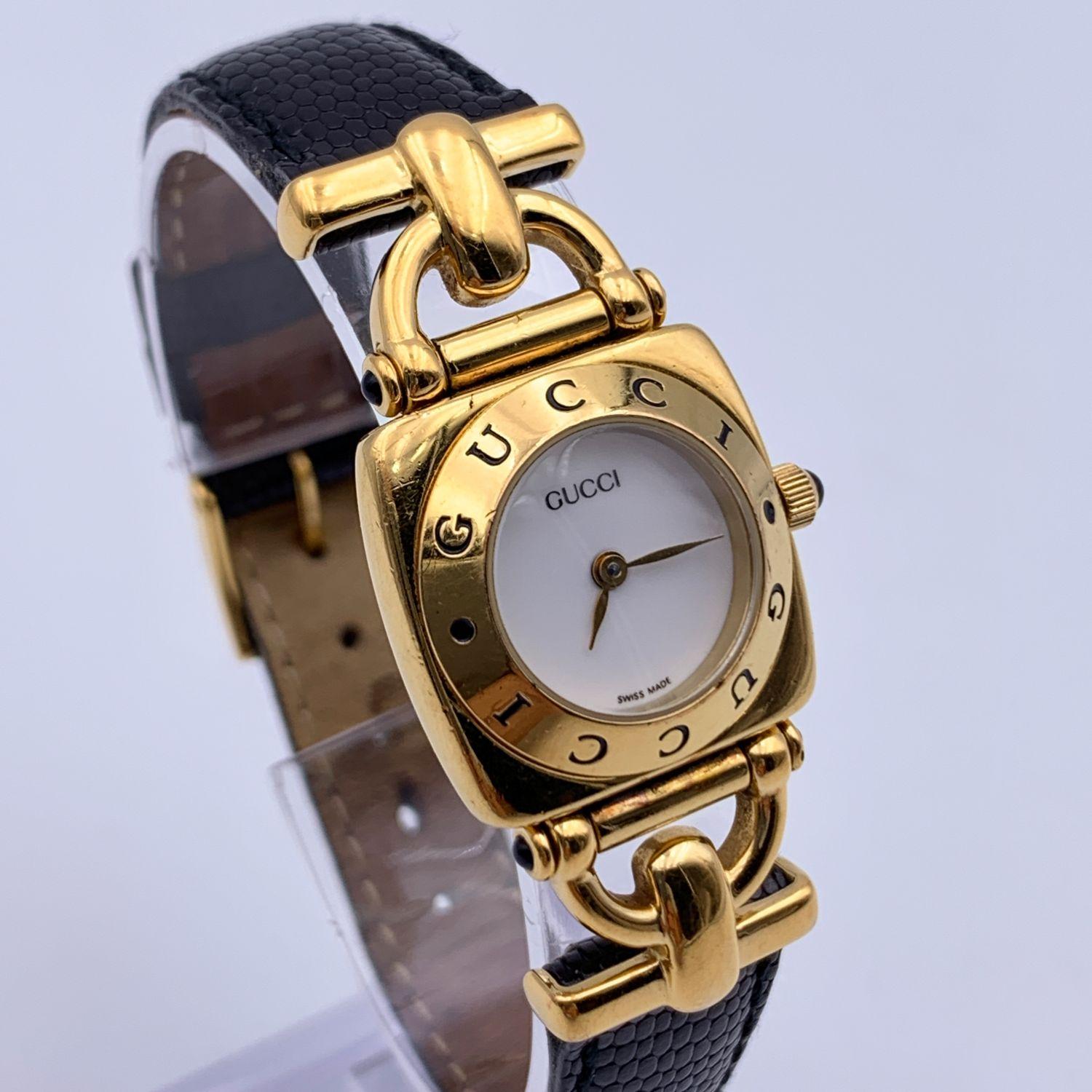 Gucci 6300 L Gold plated stainless steel wrist watch from the 90s. White dial and Sapphire crystal. Swiss Made Quartz movement. Gucci written on face and on the bezel .Water Resistant. Black leather trap with buckle closure (GG logo engraved on the