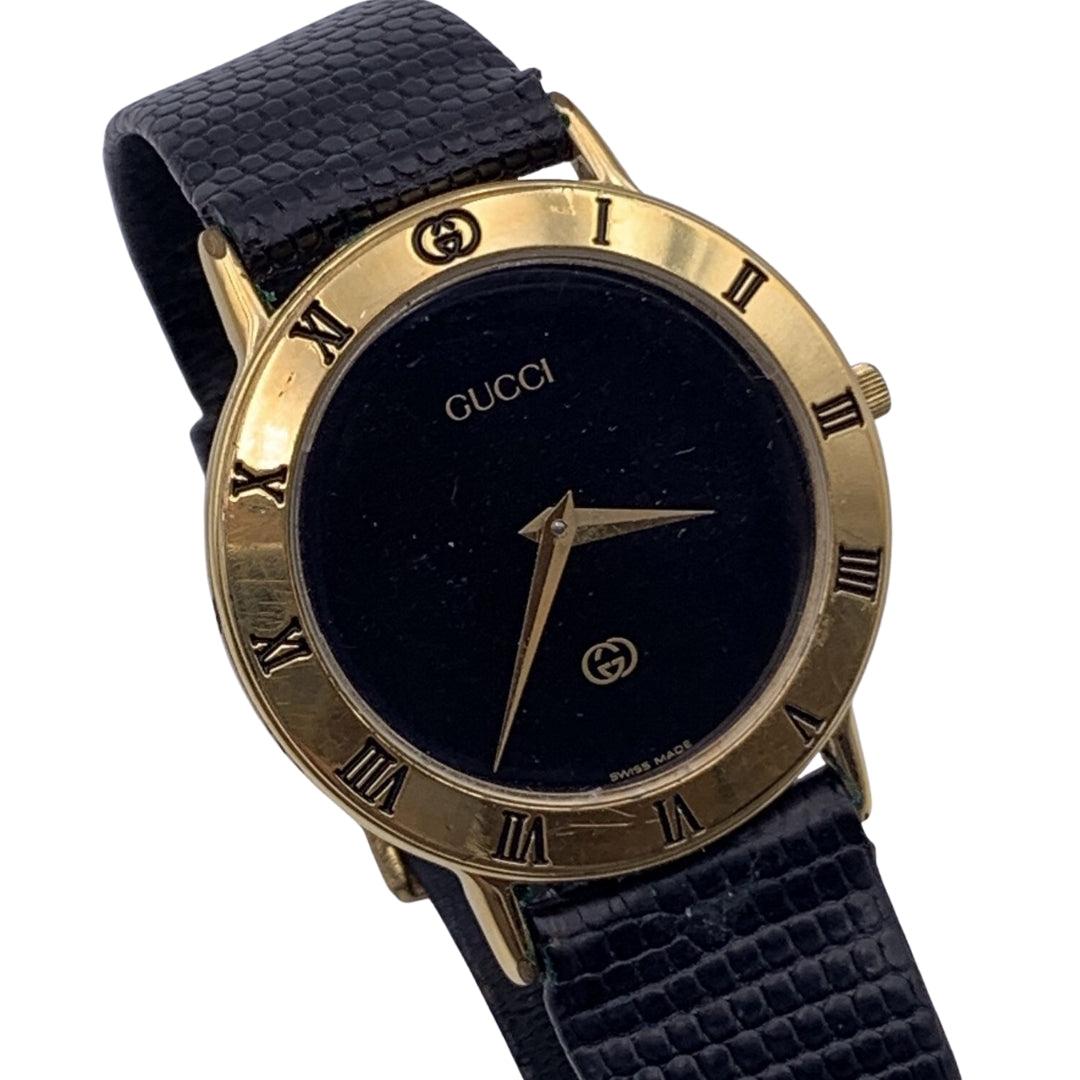 Beautiful vintage wristwatch by GUCCI. Round gold metal stainless steel case. Black dial. Swiss Made Quartz Movement. Black leather wrist strap with 6 holes adjustment. GG - GUCCI buckle. Roman numbers engraved on the bezel. 'GUCCI' lettering on the
