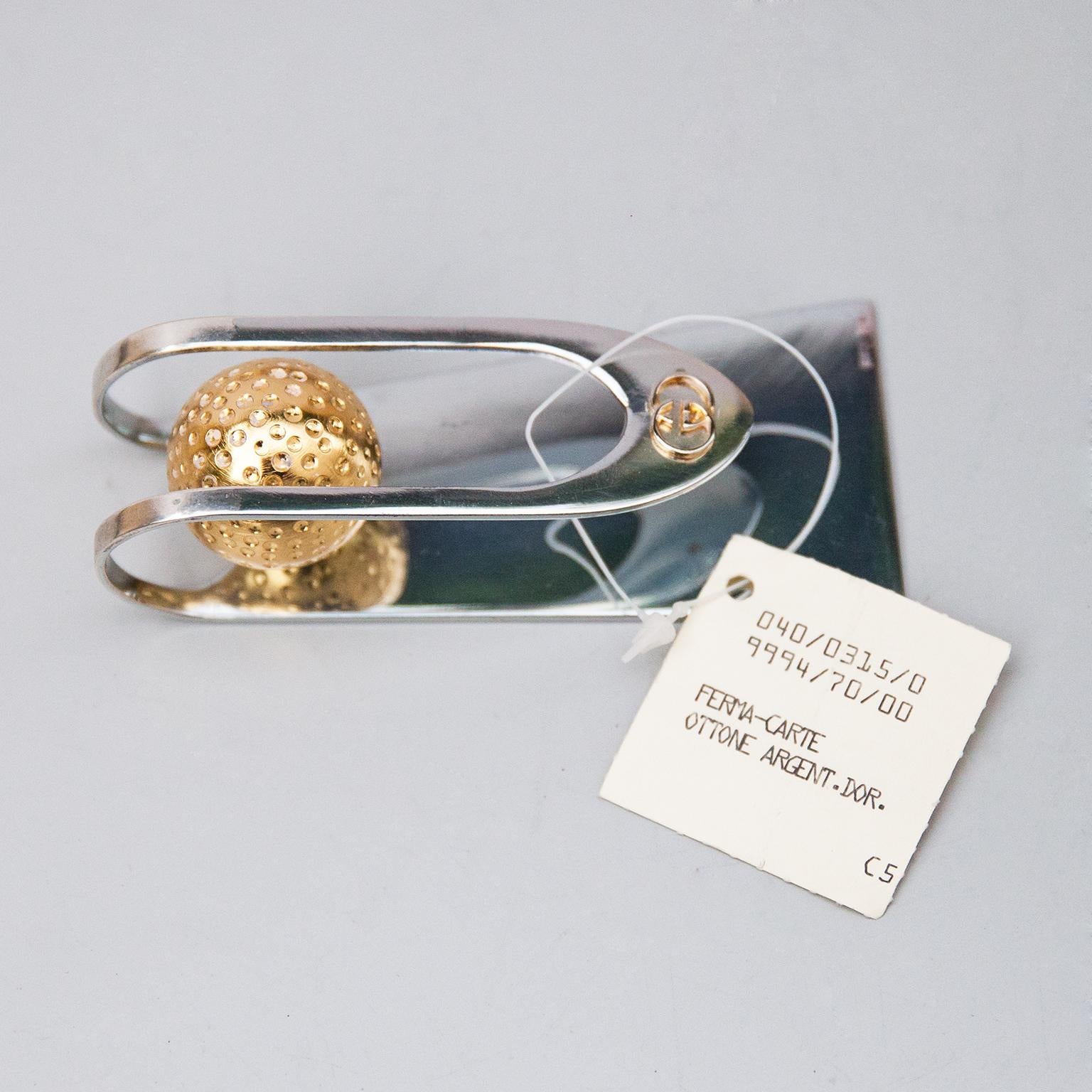 Geldtasche oder Briefumschlaghalter aus vergoldetem und versilbertem Stahl, mit der Signatur Gucci Italy auf der Unterseite.
  