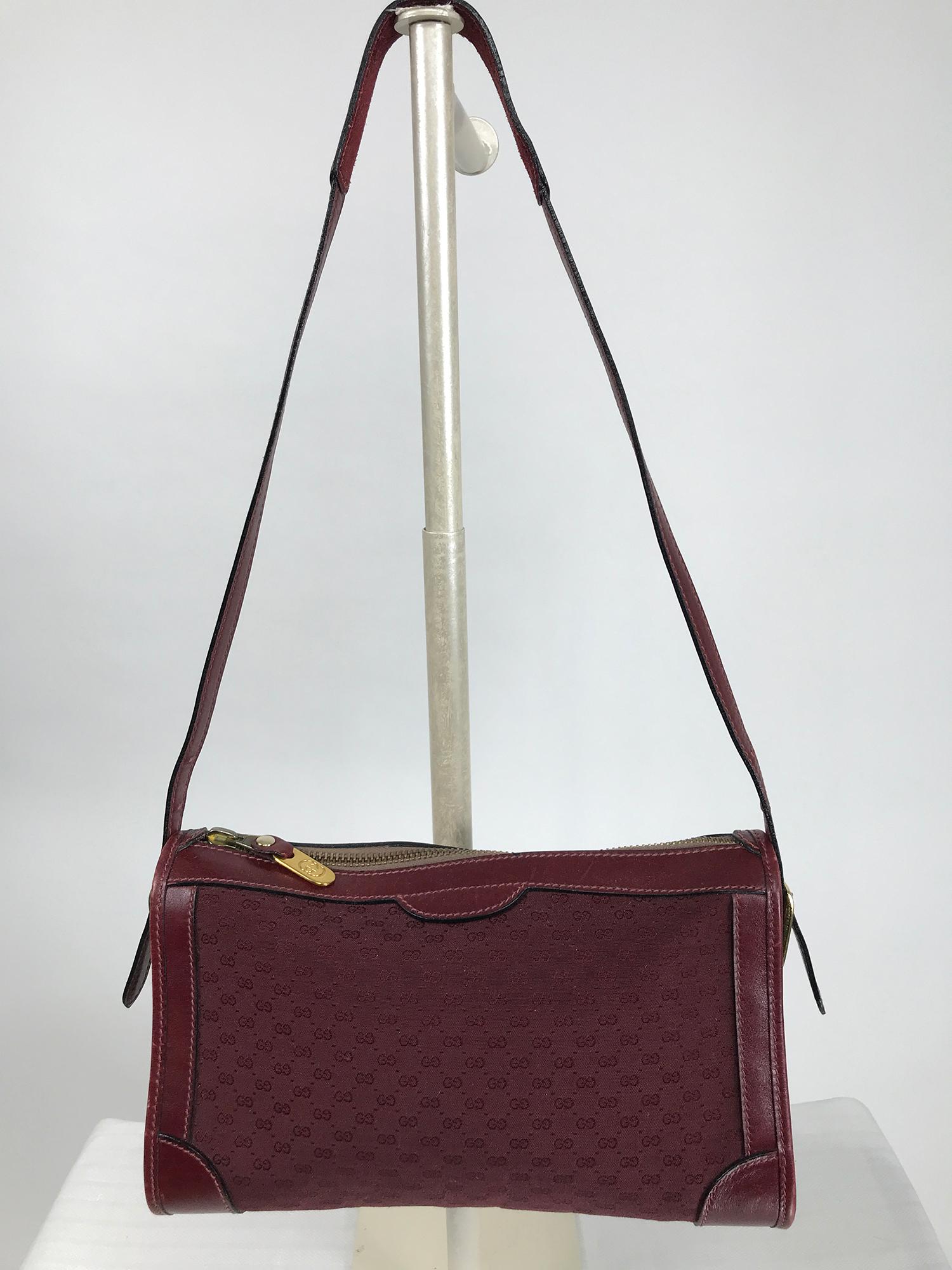 Vintage Gucci 1970s burgundy monogram canvas & leather shoulder bag. This early and rare bag has wide leather trimming along the zipper at the top, outlining each side like a frame for the canvas, there is a wide leather band at the bottom center.