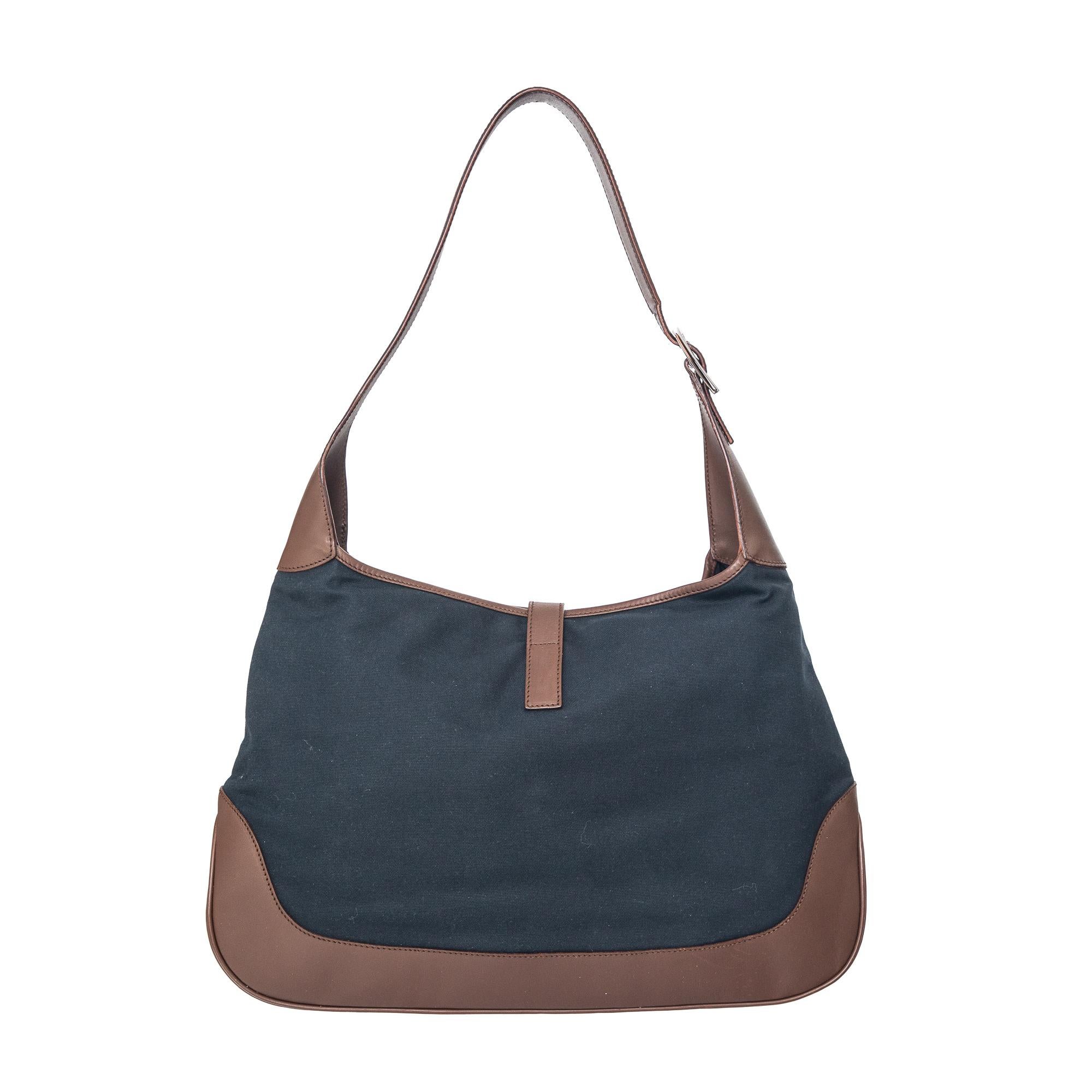 Ruder Than The Rest presents a Gucci vintage Jackie handbag in navy canvas fabric with brown leather accents.

The colours on this piece work together so well.

Woven stripe in the centre in moss green and cream.

Chrome hardware and piston