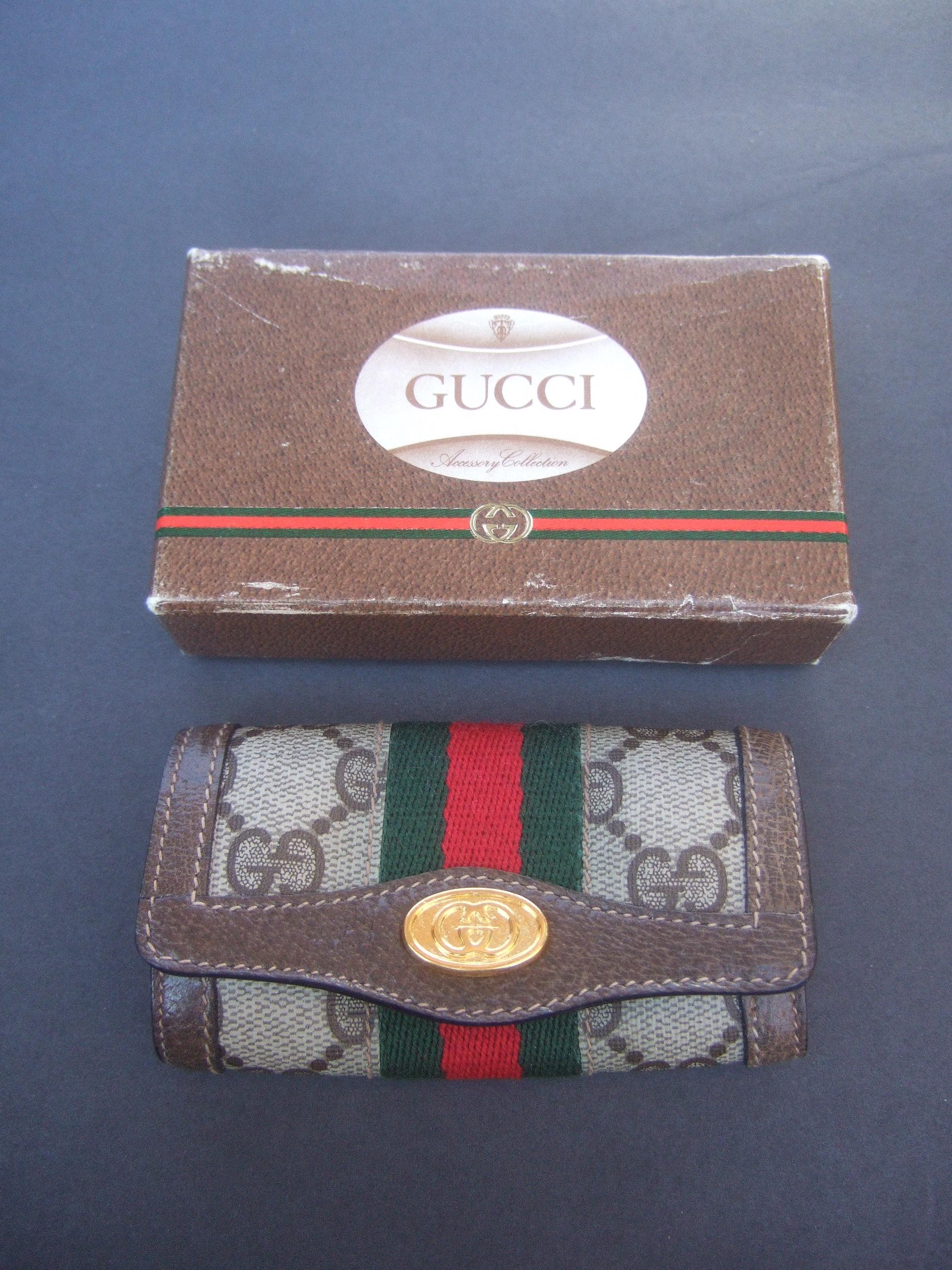 Gucci vintage keychain case in Gucci presentation box c 1980s
The stylish folded keychain case is designed with Gucci's signature coated canvas with brown leather trim

The clasp snap is adorned with Gucci's interlocked G.G. initials in gilt metal.