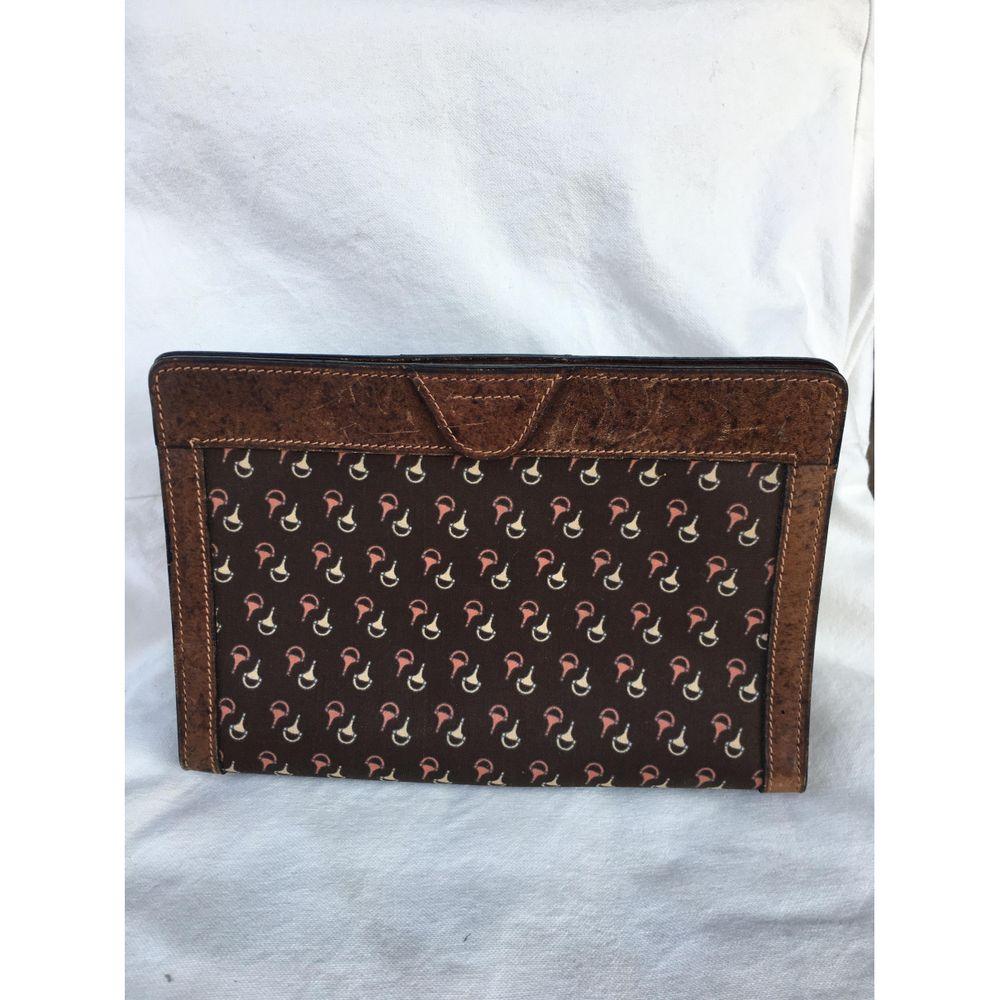 Gucci Vintage Leather Clutch Bag in Brown

Gucci clutch bag. In fabric (it would seem oilcloth) with equestrian pattern and leather. 
It can be used both as a cosmetic bag and as a clutch bag. 
Velcro closure. 
Measures 15 cm high, 23 cm long and 7