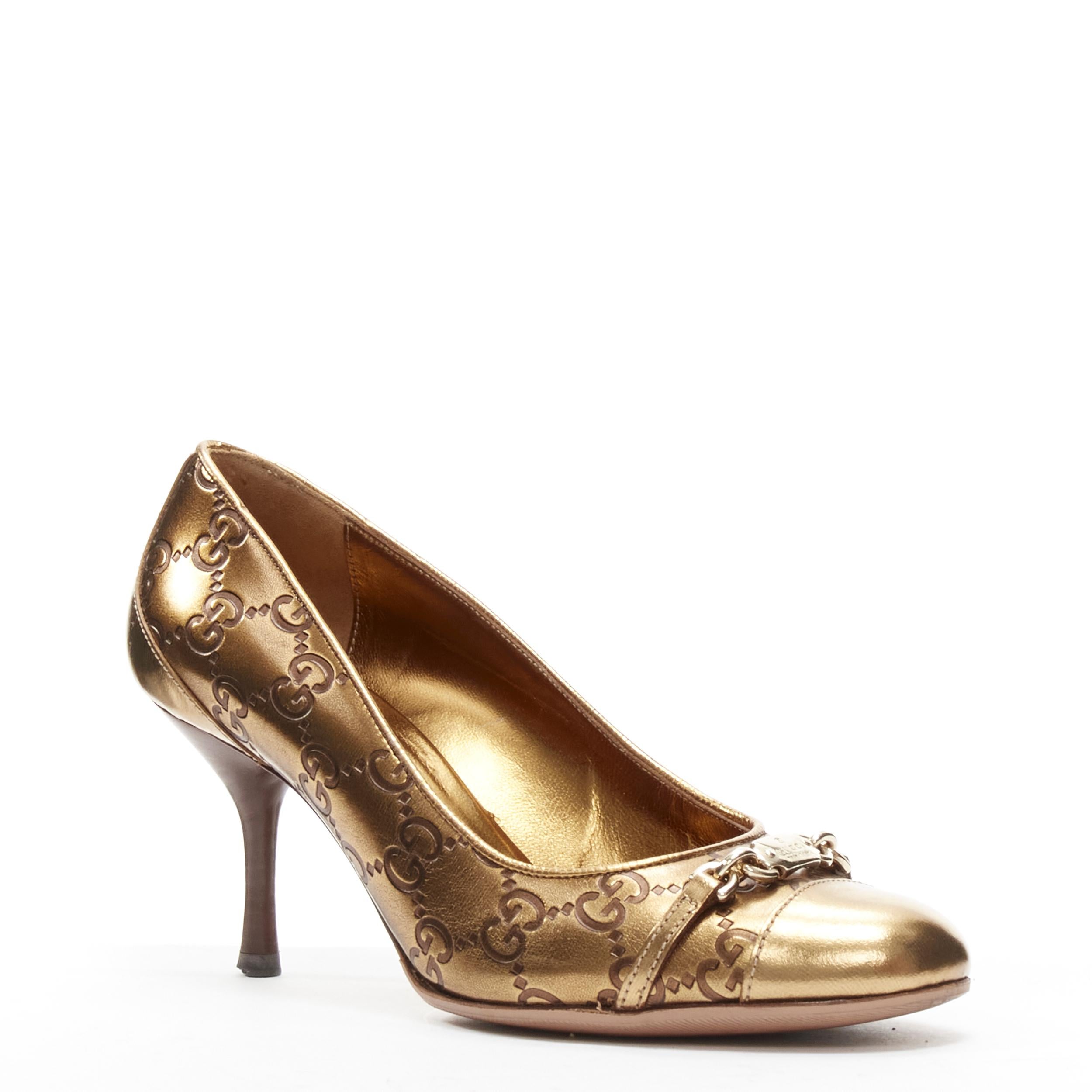GUCCI Vintage metallic gold GG monogram gold chain charm mid heel pump EU36 C
Brand: Gucci
Model: 146798
Material: Calfskin Leather
Color: Gold
Pattern: Solid
Extra Detail: Gold-tone ID plate chain detailing at toe. Stacked wooden heel.
Made in: