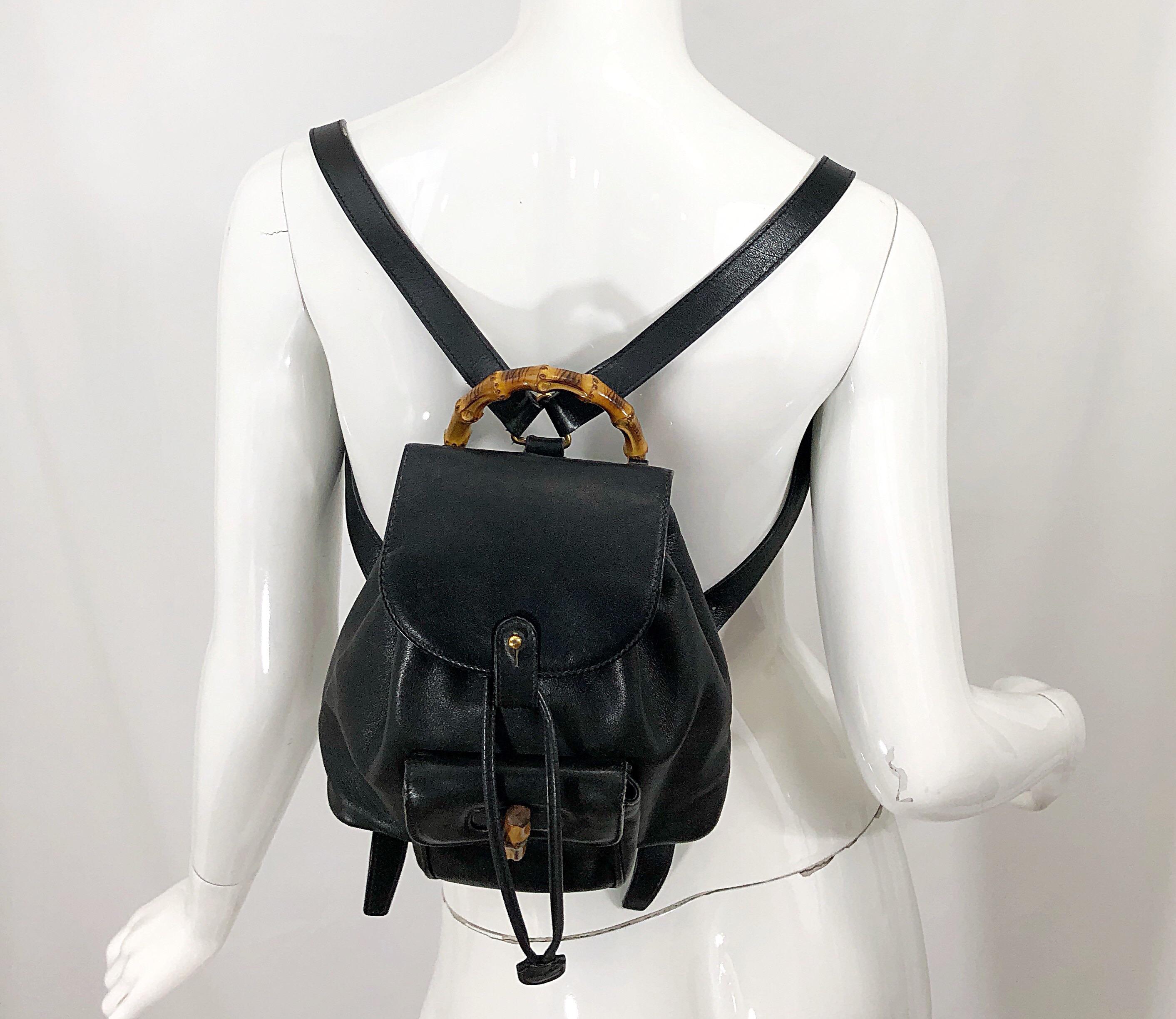 Rare vintage GUCCI black leather mini back pack! Features secure front pocket that closes shut with a brown bamboo knob. Features interior pocket. Drawstring closure securely closes the bag. Adjustable straps, with bamboo top handle. The perfect
