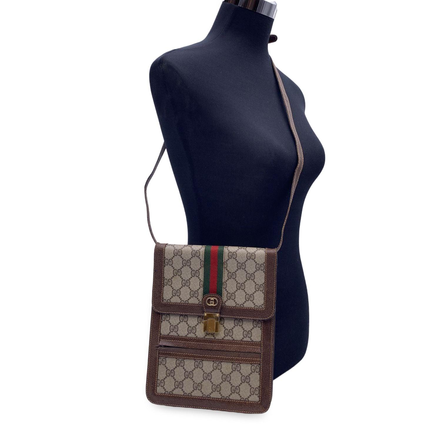 Vintage Gucci vertical shoulder bag. beige monogram canvas with brown genuine leather trim. Green/Red/Green GUCCI stripes detailing on the flap. Gold metal GG - GUCCI logo on the front. Flap with clasp closure. 1 front zip pocket. Removable &