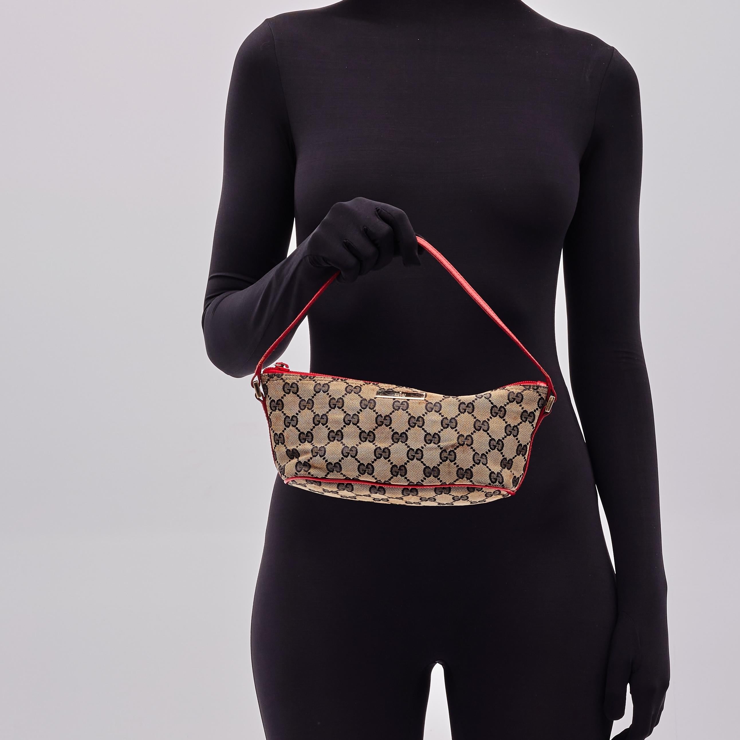 Questa borsa è realizzata in tela marrone e beige con stampa Monogram. La borsa presenta finiture in pelle rossa, una tracolla superiore e una chiusura a zip. La borsa si apre con un interno in tessuto nero. Borsa vintage.

Colore: marrone con