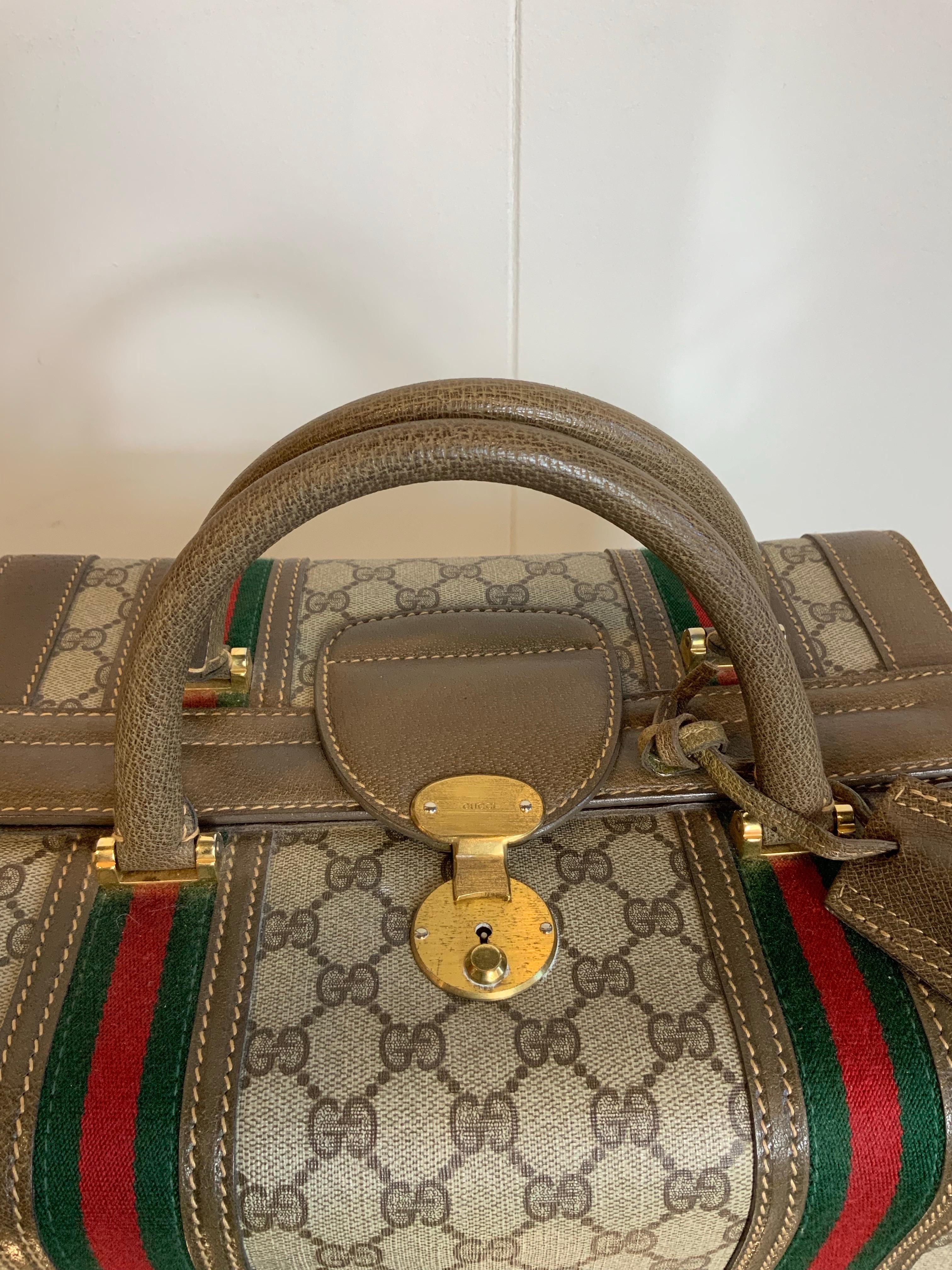 Vintage Gucci small trunk.
in Monogram leather and brown leather details with two red and green fabric bands. 
Light brown leather interior with a zip pocket.
It has a double adjustable internal strap and can be used as a product container.
Golden