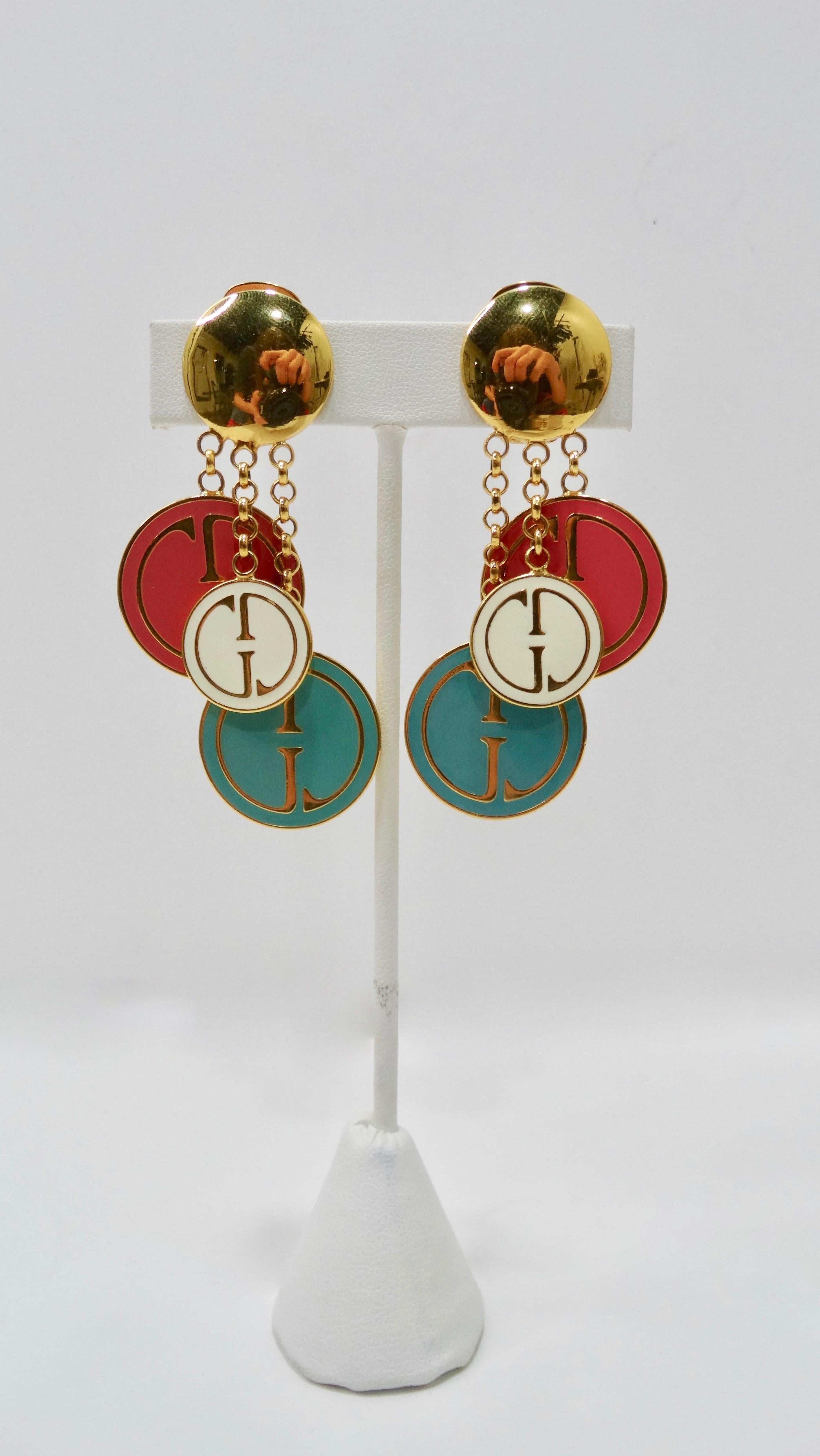 Add a new addition to your jewelry collection with these adorable Gucci earrings! Circa 1991, these gold toned dangle earrings revive the 1970s/1980s by featuring the vintage Gucci logo on white, pink and blue enamel embossed charms that hang freely