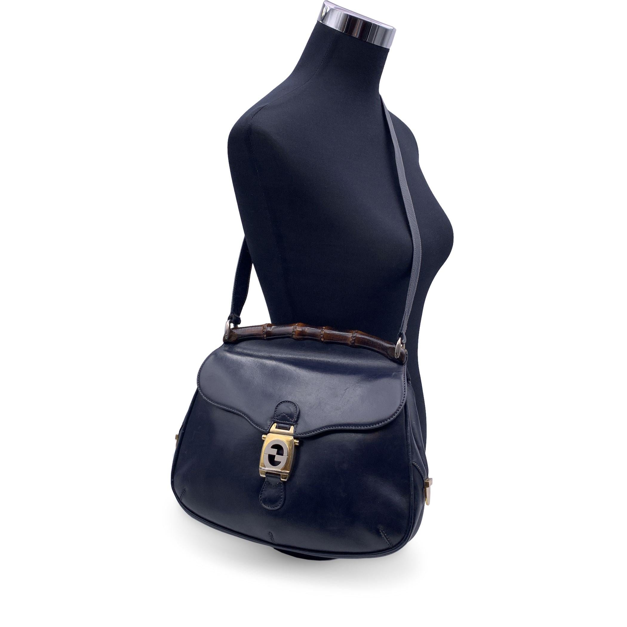 Beautiful Vintage Gucci bamboo shoulder bag crafted in navy blue leather. Bamboo accent on top. Flap with interlocking GG clasp closure.Adjustable shoulder strap. Blue suede lining. 1 side open pocket and 1 side zip pocket inside. 'Made in Italy by