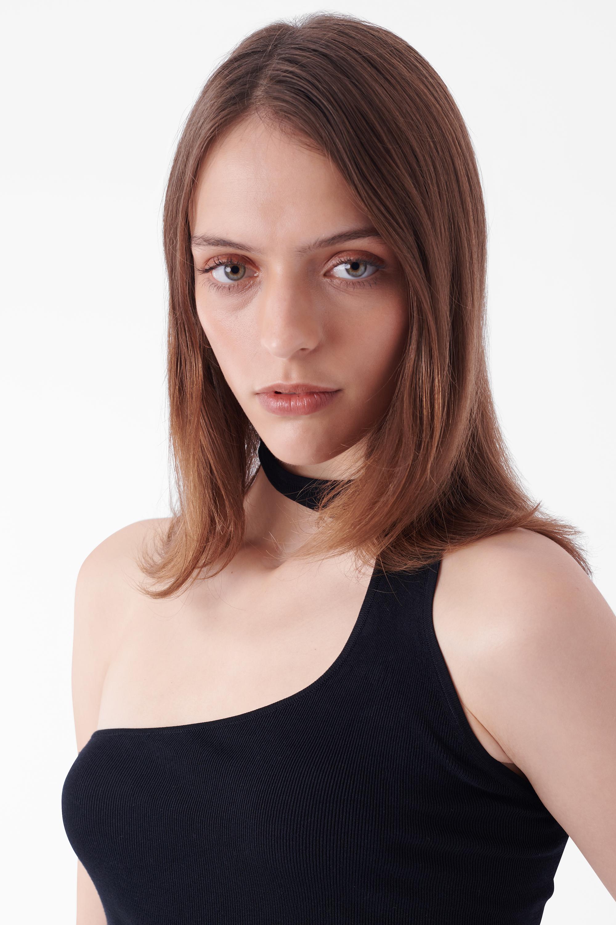 Top nero monospalla Tom Ford for Gucci. Caratterizzato da una scollatura asimmetrica, un buco nel collo e un design senza maniche con una vestibilità bodycon elasticizzata. In ottime condizioni vintage.

Abbinato ai nostri 'Pantaloni neri a V Gucci