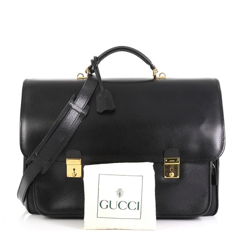 This Gucci Vintage Pocket Briefcase Leather Medium, crafted in black leather, features a leather top handle, frontal flap with two push-lock closures, two exterior front zip pockets, and gold-tone hardware. Its flap opens to a beige microfiber