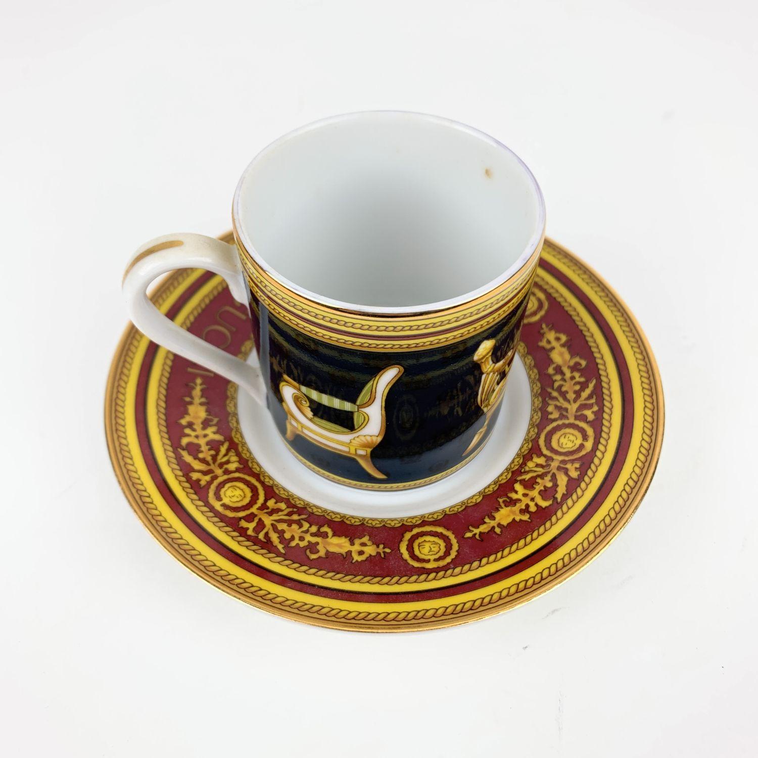 Vintage Gucci porcelain coffee cup and saucer. Crafted of fine porcelain. The cup feature an upper gold rim, a chair designs on a dark blue background . The saucer is in burgundy and yellow color with GUCCI signature on top. 'Gucci Porcellana'