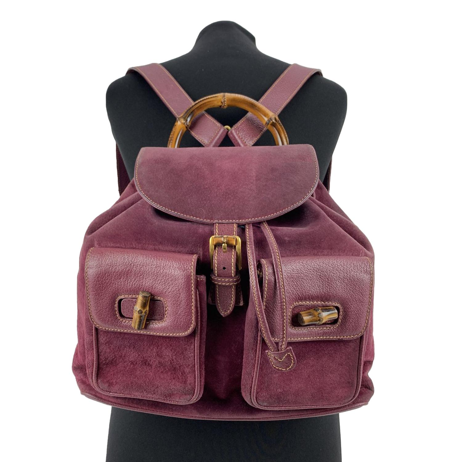 Vintage backpack by Gucci, crafted in purple suede and leather. It features Bamboo handle and knobs. 2 front flap pockets.Flap with buckle closure and drawstring top opening. Internal diamond lining. 1 side zipper pocket inside (GUCCI - GG gold