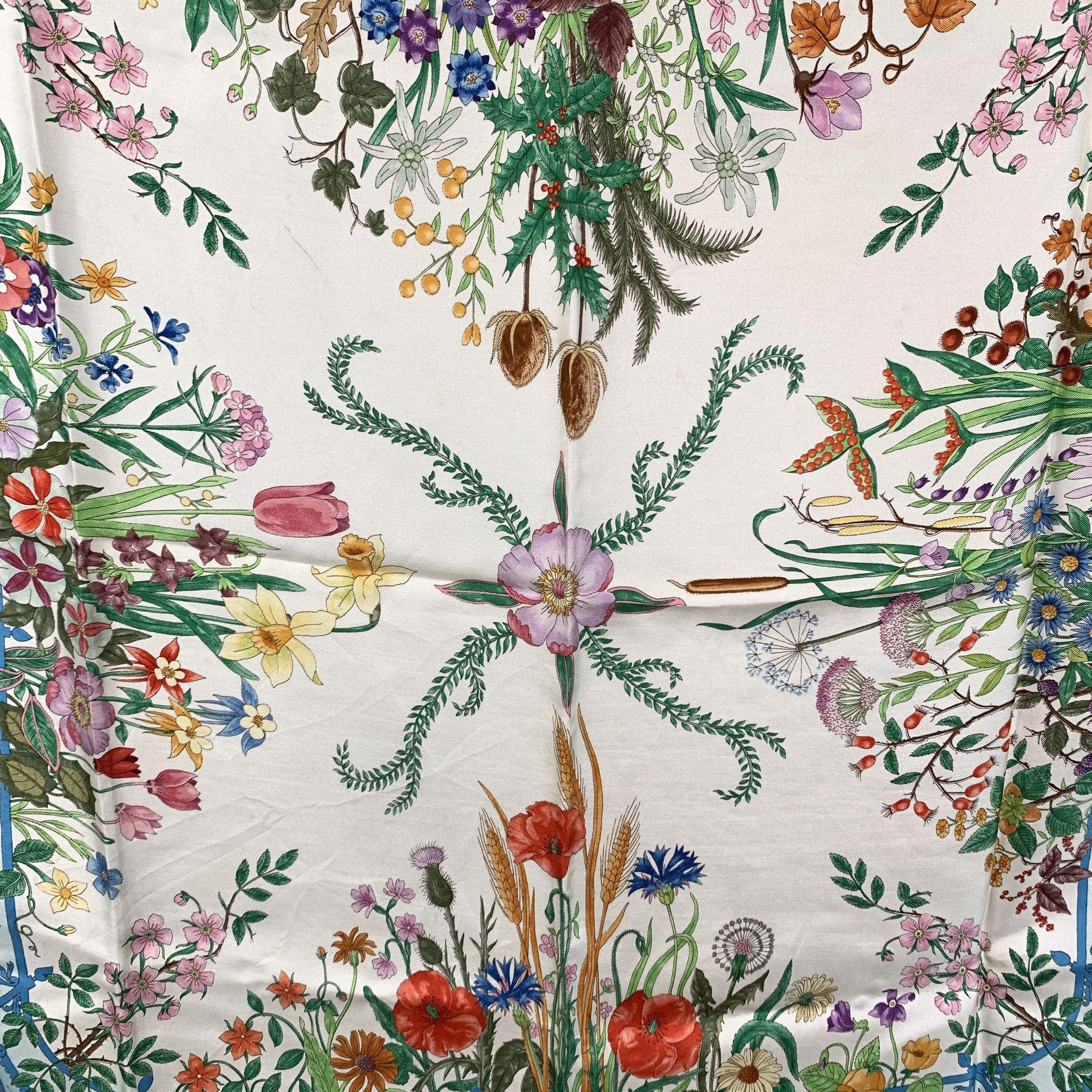 Gucci vintage silk scarf design by Vittorio Accornero. Multicolorfloral design . Blue borders. 100% Silk - Printed GUCCI signature, 'V.Accornero' signature printed on the scarf. Gucci composition tag still attached. Condition B - VERY GOOD Some blue