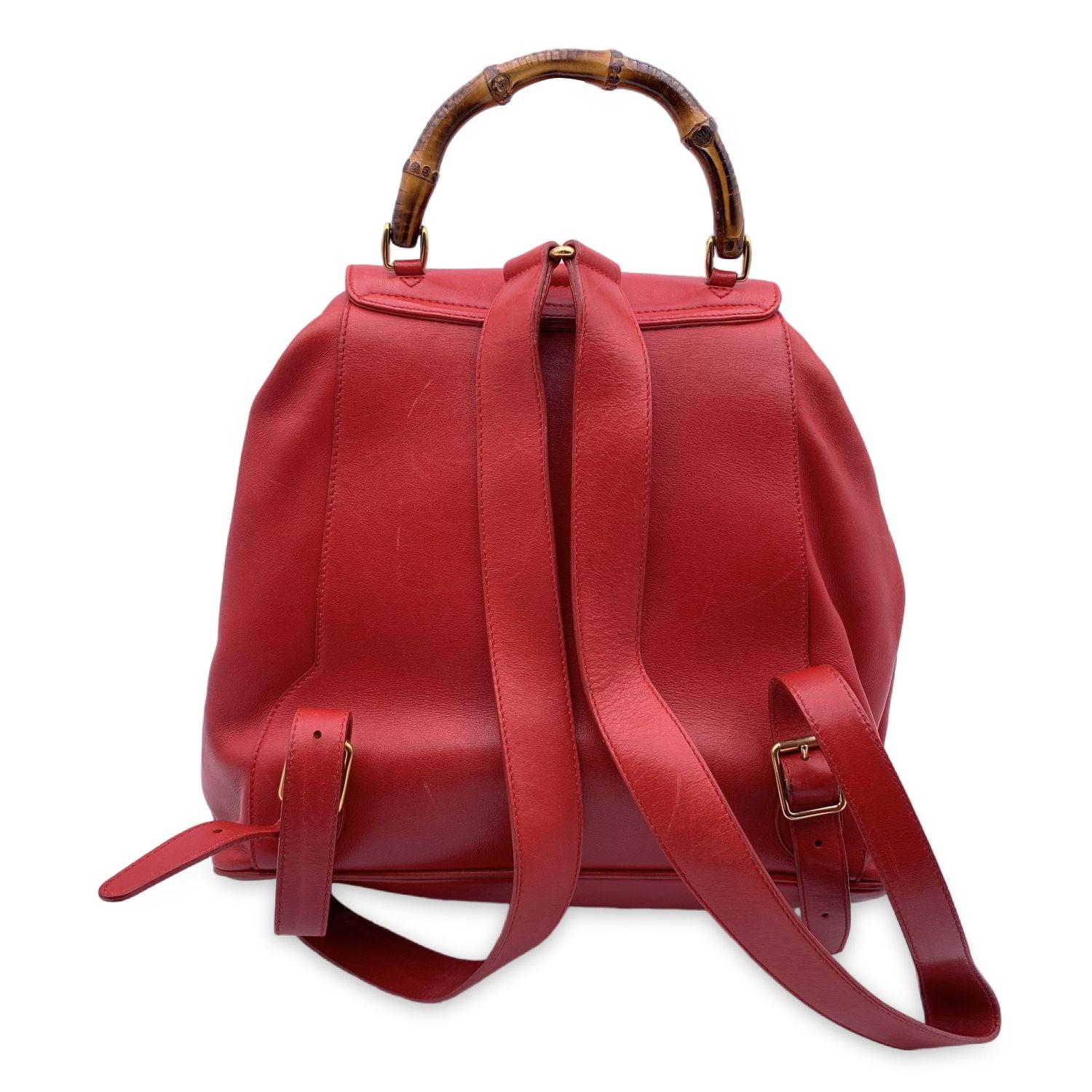 Vintage backpack by Gucci, crafted in red leather. It features Bamboo handle and and knobs. Flap with buckle closure and drawstring top opening. Internal black diamond lining. 1 side zipper pocket inside. Adjustable backstraps. 'GUCCI - Made in