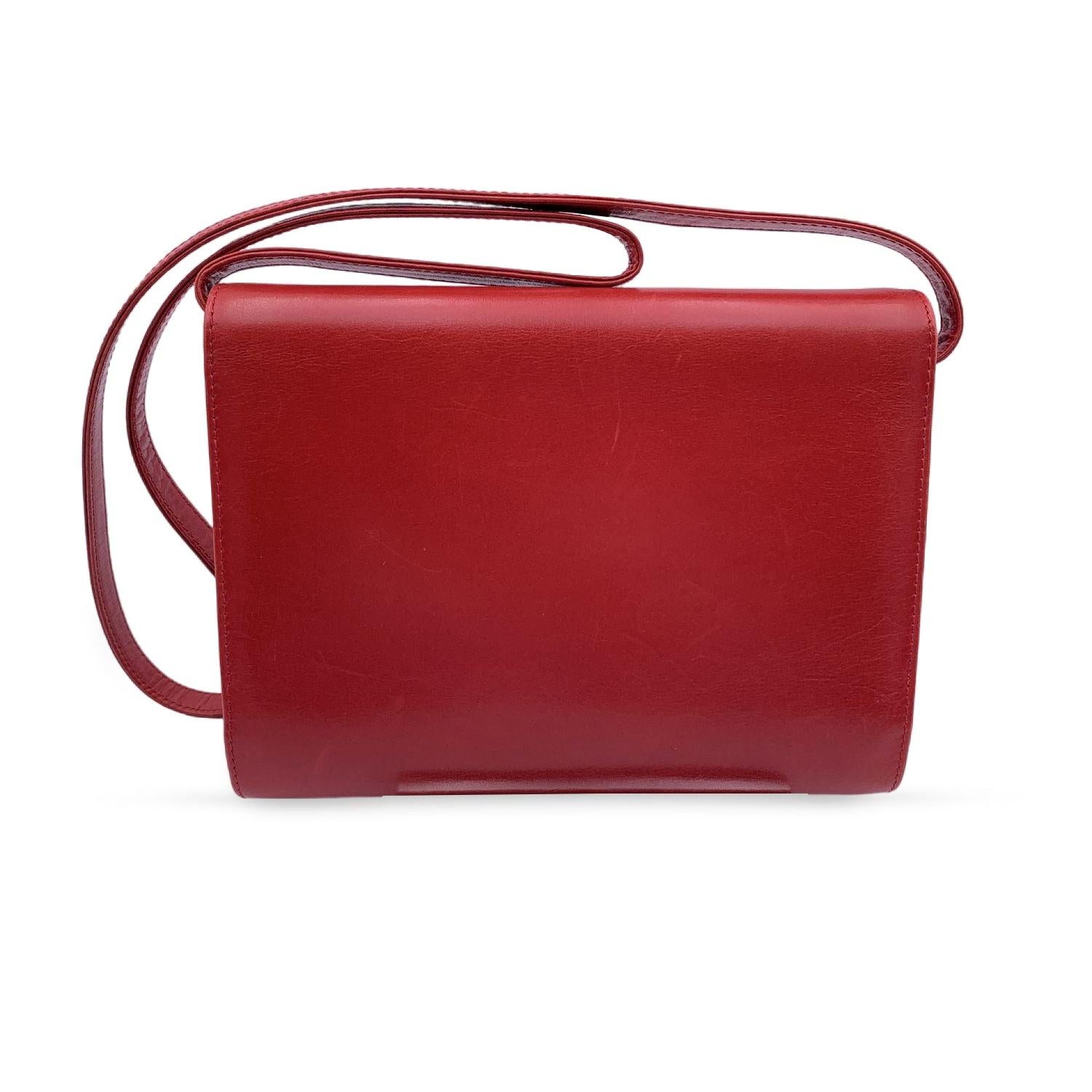 Vintage Gucci red leather shoulder bag. Gold metal accents. Flap with button closure on the front. Black leather inside. 1 side open pocket inside. Removable shoulder strap (can be used as a shoulder bag or as a clutch purse if you remove its
