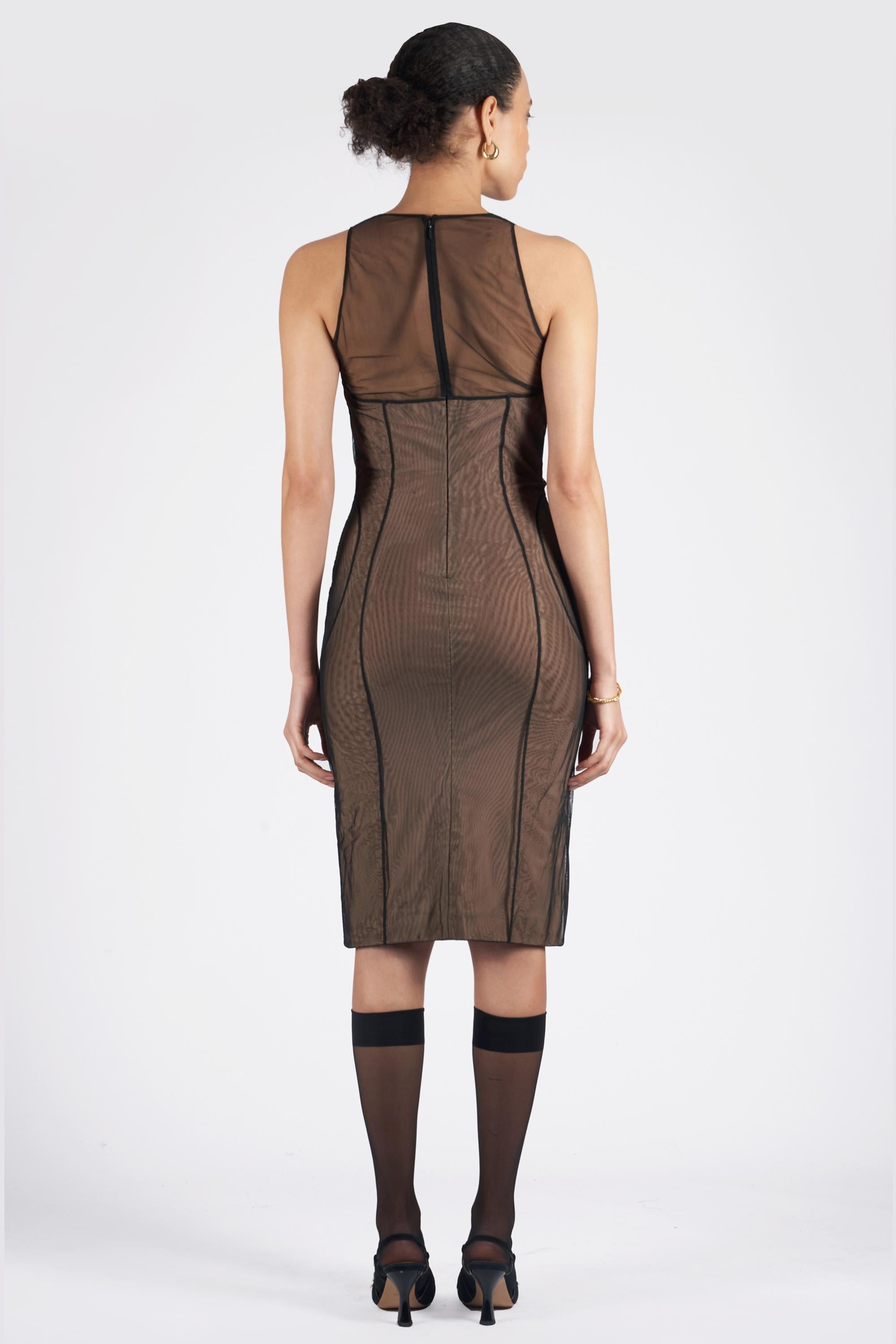 Nous avons le plaisir de vous présenter cette robe corset bodycon Gucci by Tom Ford Spring Summer 2001, d'une rareté inouïe. Ce corset bustier recouvert de tulle transparent est doté d'un col rond, d'un corsage structuré et d'une fermeture à