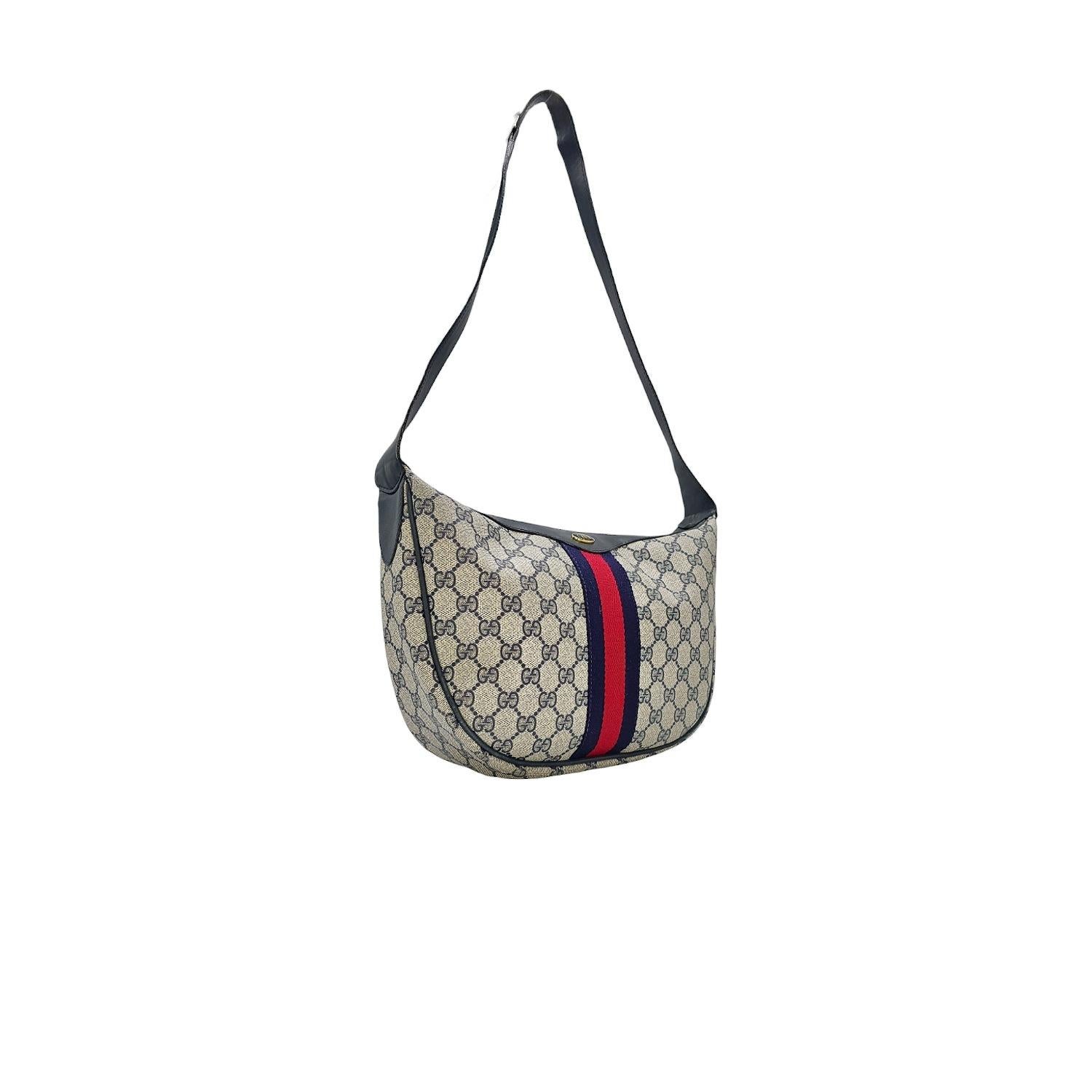 Expertly crafted in Italy, the Gucci Vintage Sherry Ophidia Web Navy Crossbody combines the iconic GG Supreme monogrammed canvas with a stylish blue and red web stripe and navy leather trim. Its spacious interior includes a zip pocket, perfect for
