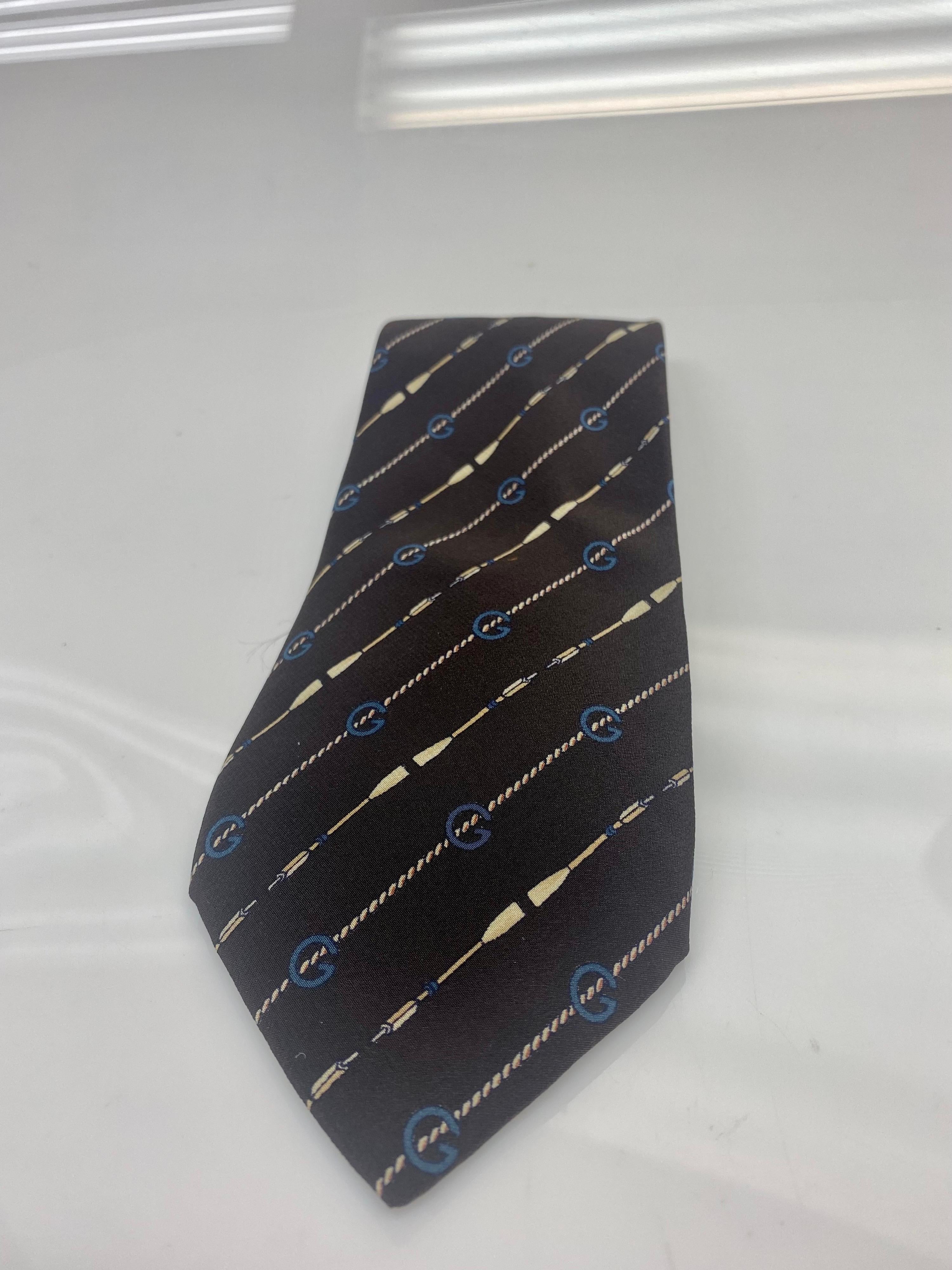 Gucci vintage silk chocolate brown GG monogram and blue G detailing 
Sophisticated and classic piece and a perfect addition to any wardrobe. Item is in good condition, wear consistent with age. Some threading in the back of the tie and Gucci tag