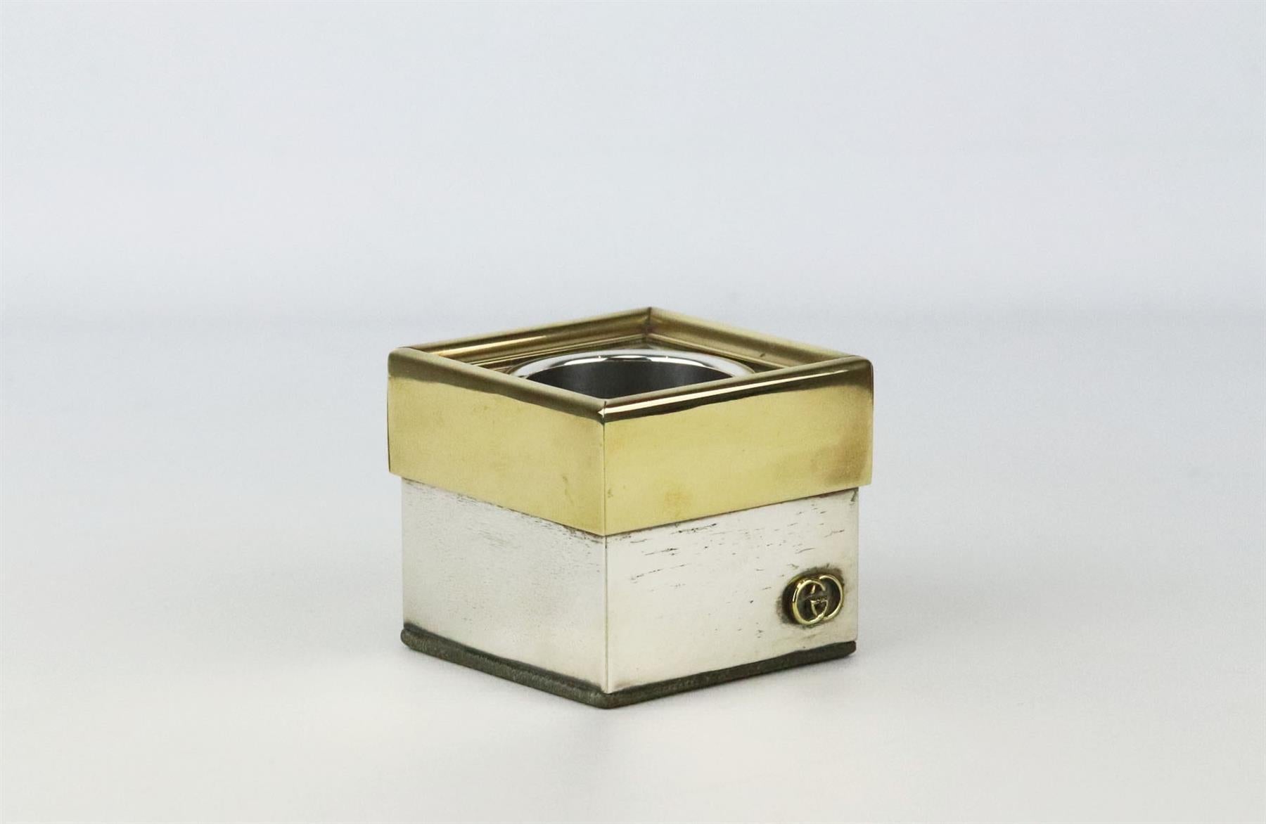 This Vintage cigarette holder by Gucci is made from silver and gold tone metal in a square shape and GG detail, store your cigarettes upright inside. Does not come with box. Dimensions: H 2.5 x W 2.5 inches
