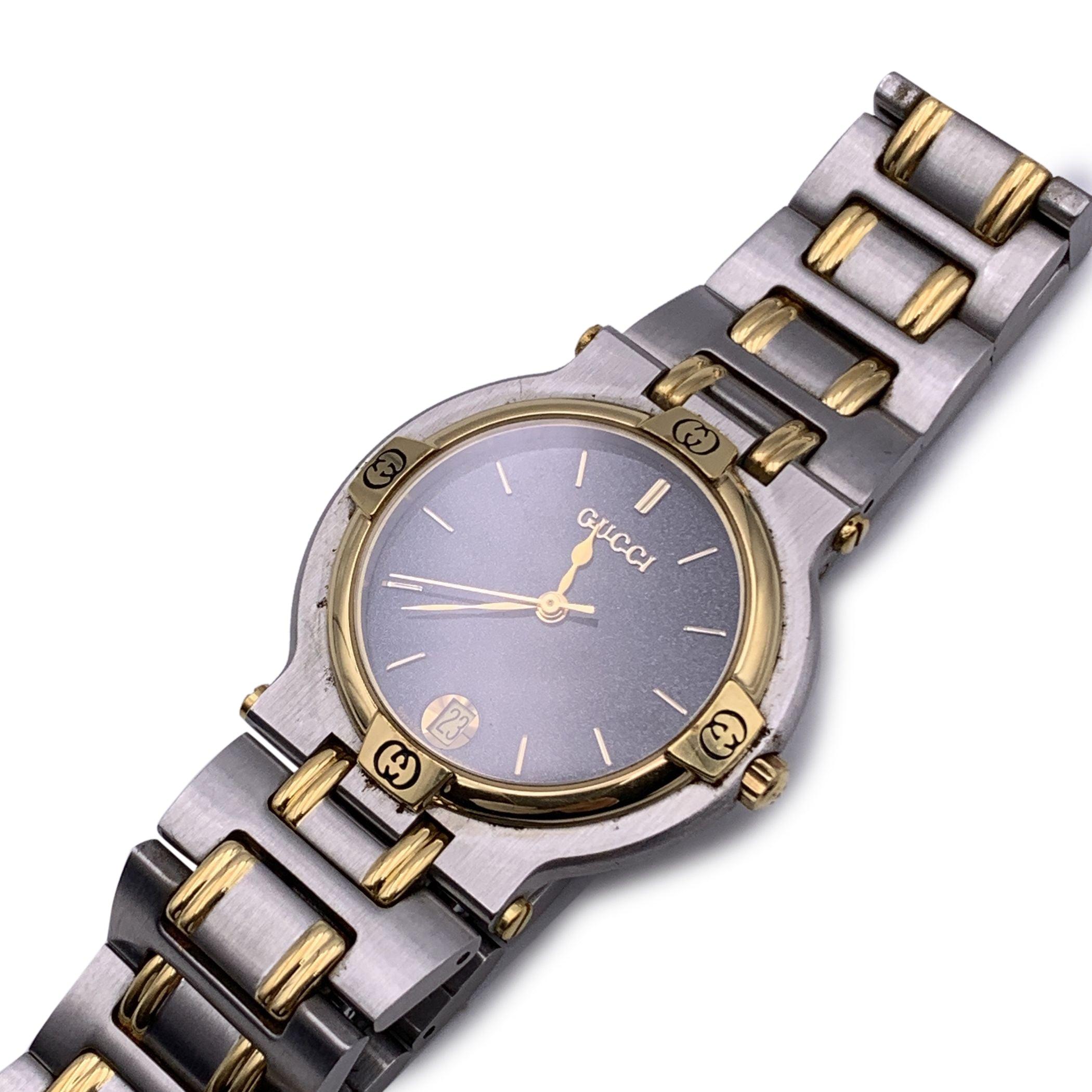 Gucci Mod. '9000 M' stainless steel wrist watch. Stainless steel round case with gold plated bezel detailed with GG logos. Gold-tone dial with gold hands and markers. Sapphire crystal. Date indicator. Swiss quartz movement. Stainless steel and gold