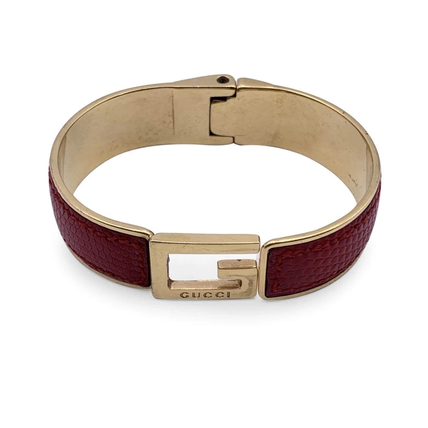 Gold-Tone Stainless steel bangle bracelet with G logo by GUCCI. Red leather. Spring hinge for easy wearing. Made in Italy. Diameter (Max width): 2.5 inches - 6.5 cm, min width: 2 inches - 5 cm. Internal circumference: 7.5 inches - 19.05 cm

A -