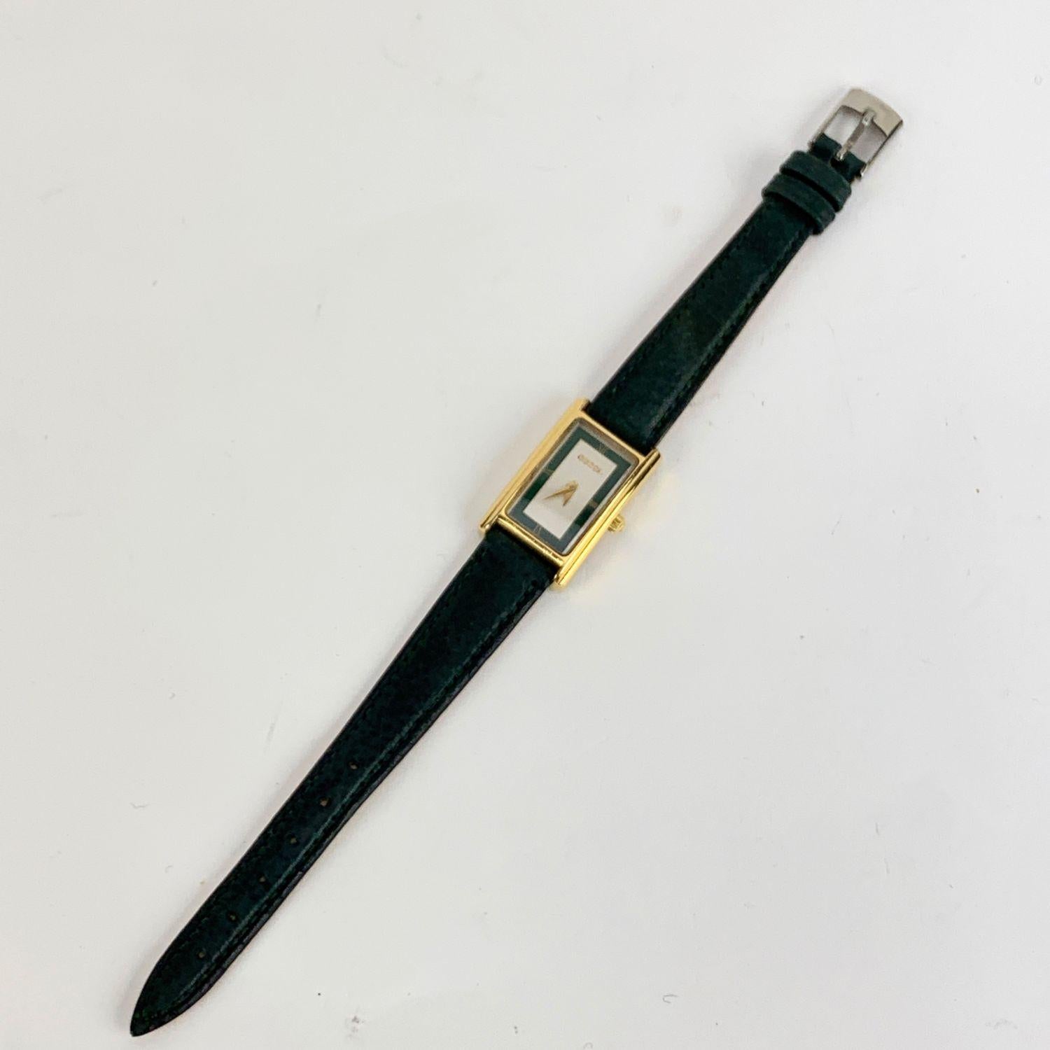Beautiful vintage wristwatch by GUCCI, Mod. 2600 L. Rectangular gold metal stainless steel case. Swiss Made Quartz Movement. Green leather wrist strap with 6 holes adjustment. White and green dial with roman numbers. 'GUCCI' lettering on the dial.