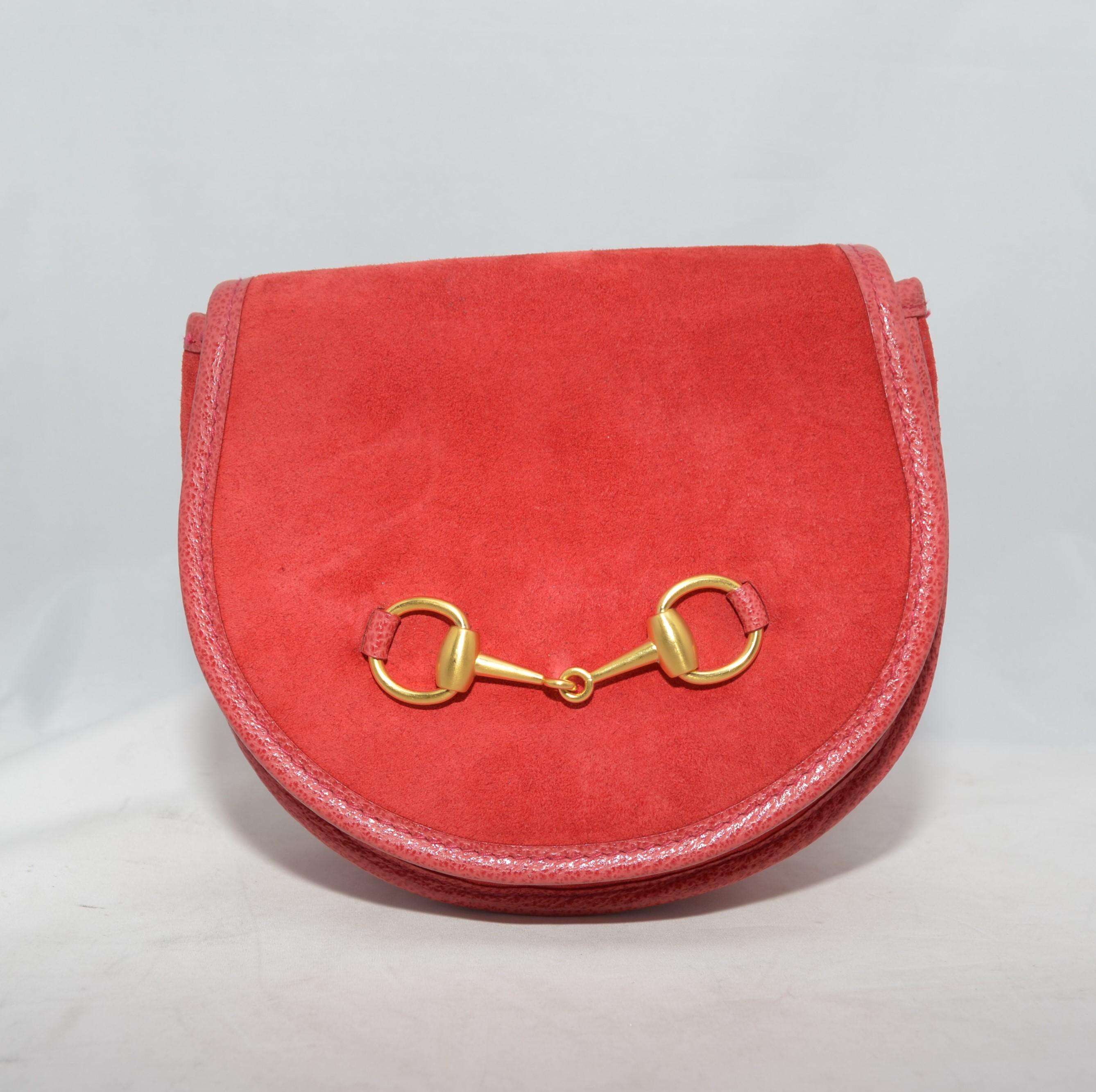 Vintage Gucci belt bag featured in red suede leather with a gold-tone horsebit detail at the front, flap front with a snap button closure, and a full leather lining. Belt measures 37 inches long and 1-inch wide.  Bag is in great vintage condition