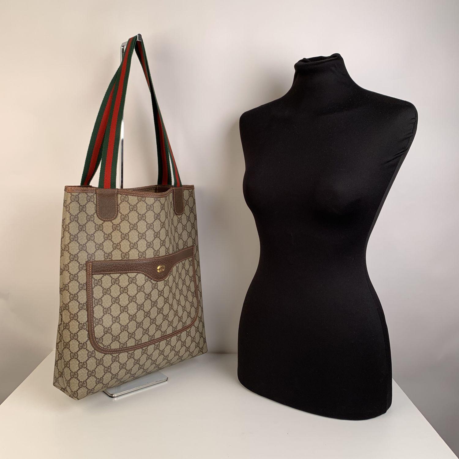 Beautiful Gucci tote made in monogram canvas with brown leather trim. Green/Red/Green striped canvas shoulder straps. 1 front patch pocket. Enameled GG- GUCCI logo tab on the front. Tan canvas lining. 'GUCCI Accessory collection - Made in Italy' tag