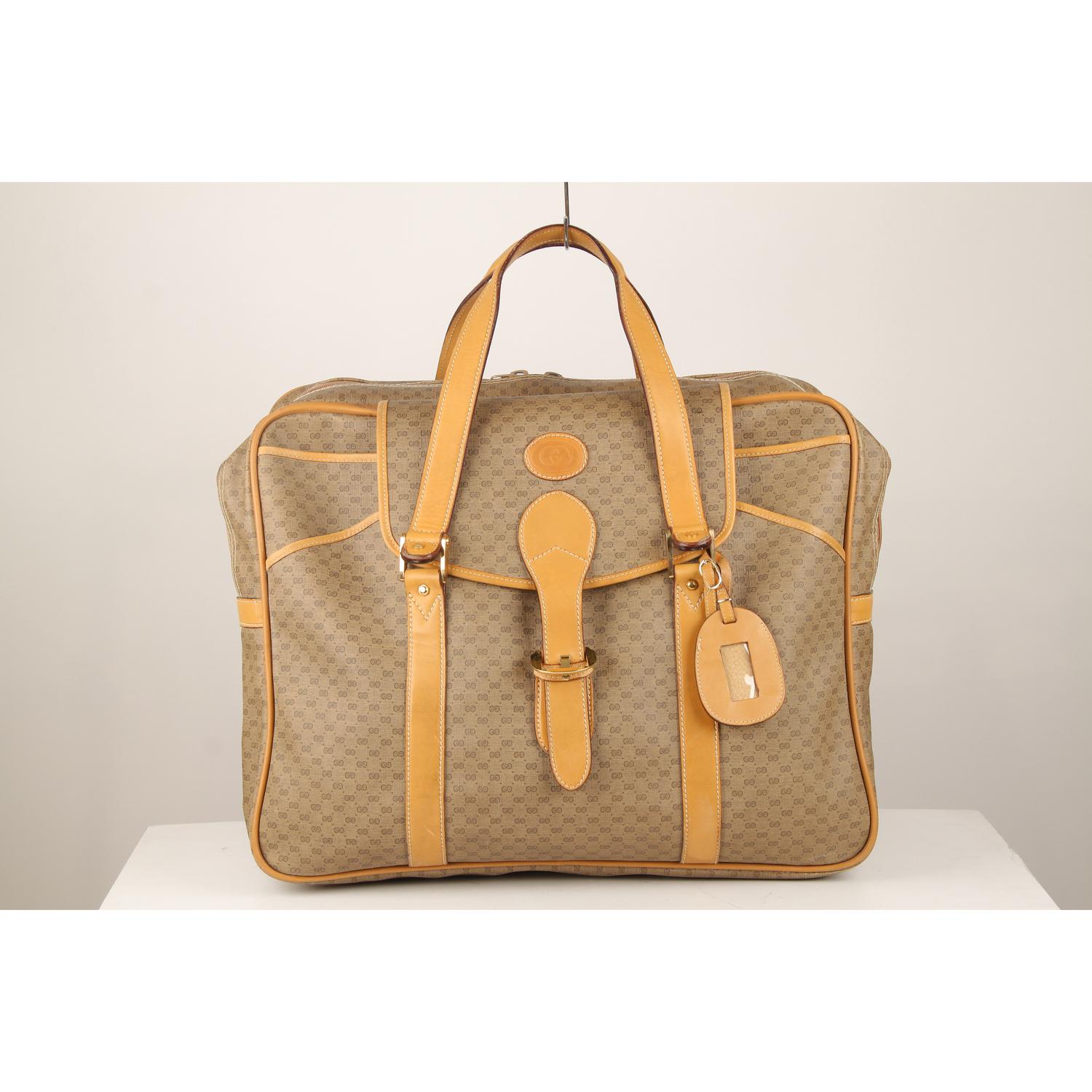 Tan GG monogram canvas travel bag by GUCCI with tan leather trim. 2 main compartments with upper zipper closure. Front open sections closed by a front flap with buckle closure. Diamond fabric lining. 1 side zip pocket inside 'GUCCI - Made in Italy'