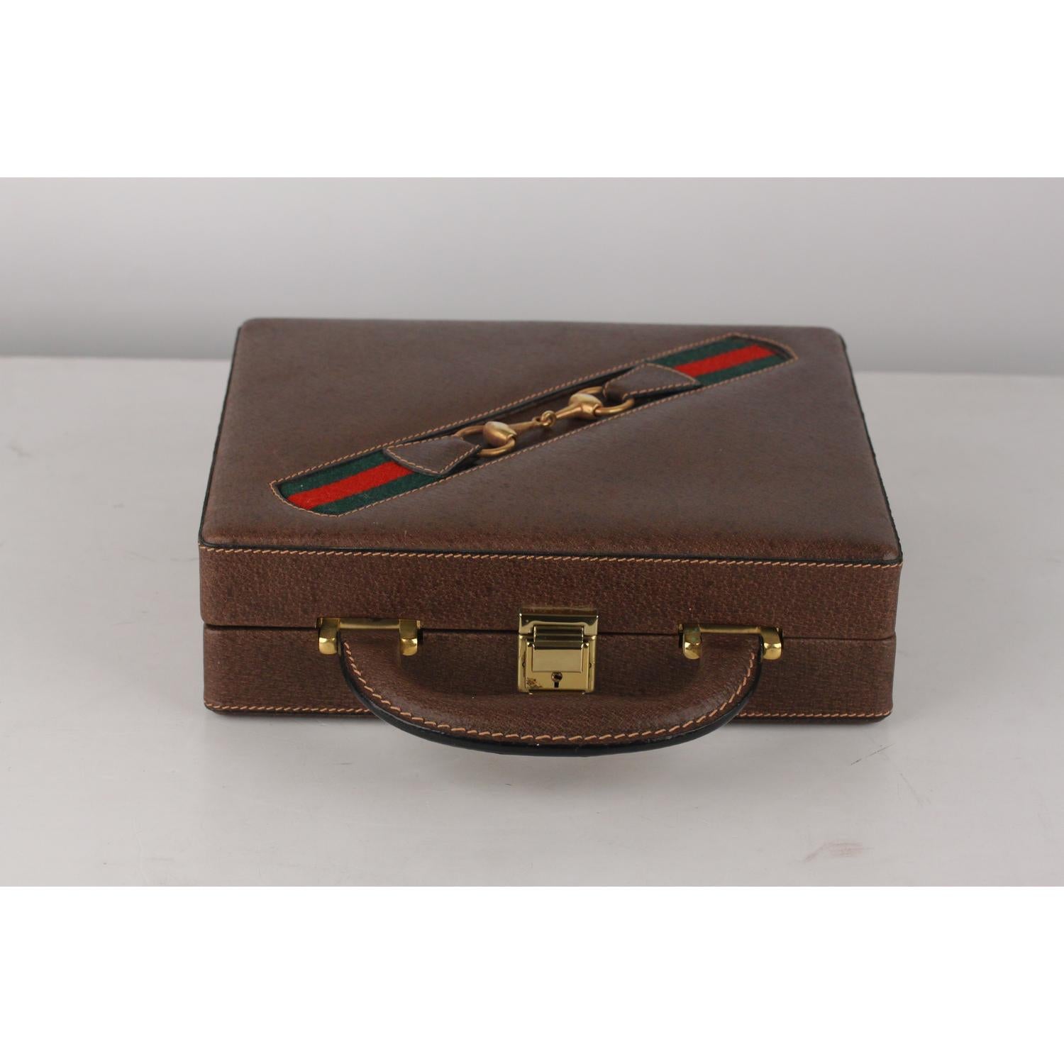 Rare travel poker set was made by Gucci, from the 70s.  The travel case is made from dark pigskin leather and features Gucci's iconic green/red/green striping with a gold metal horsebit. the case is lined in green felt and it hs one divider tray. 