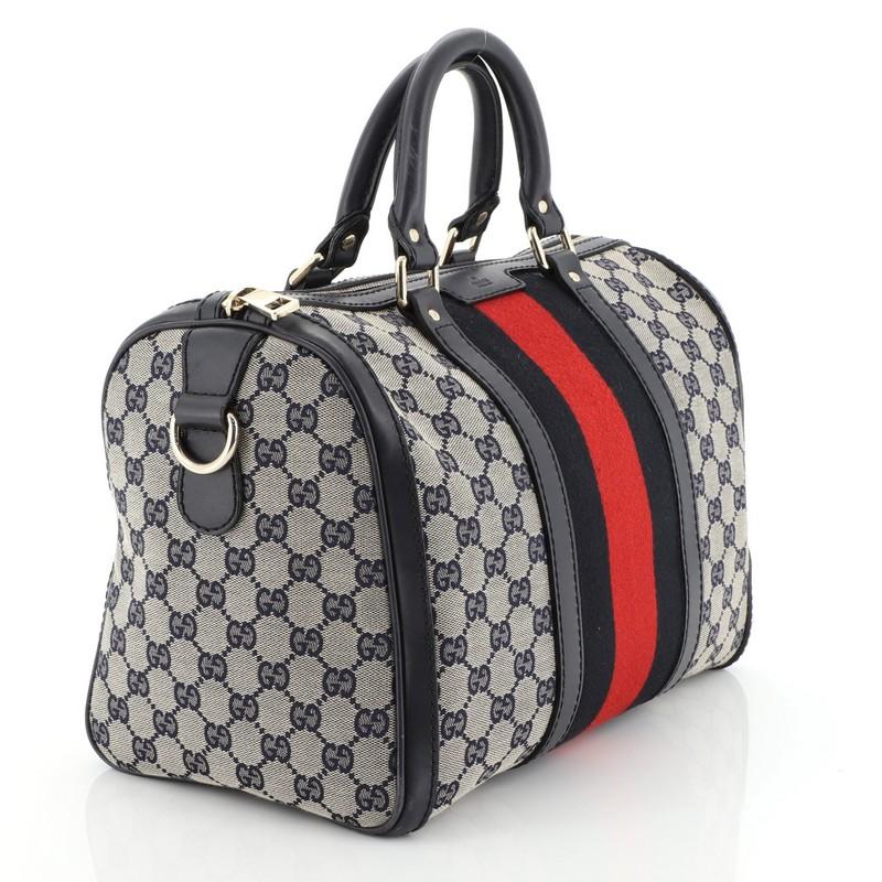 This Gucci Vintage Web Boston Bag GG Canvas Medium, crafted with neutral GG canvas, features dual rolled handles, signature web stripes, protective base studs, leather trim and gold-tone hardware. Its zip closure opens to a neutral fabric interior