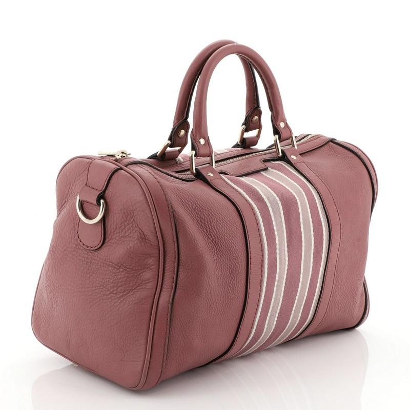 This Gucci Vintage Web Boston Bag Leather Medium, crafted from pink leather, features dual rolled handles, signature web stripes, protective base studs, and gold-tone hardware. Its zip closure opens to a neutral fabric interior with side zip and