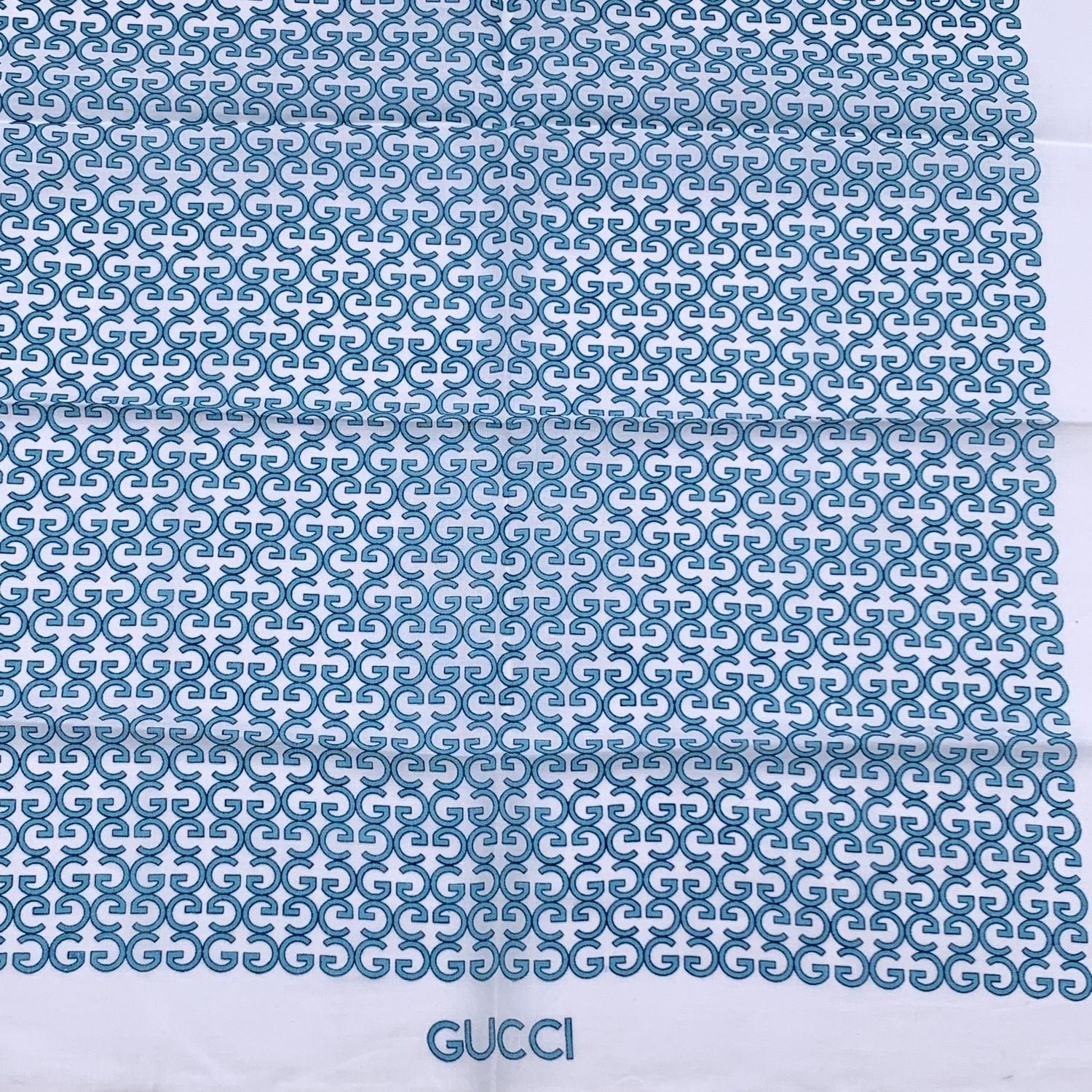 Vintage neck scarf by GUCCI. 100% Cotton. Blue GG logo pattern with white borders. 'Gucci' signature printed on the lower center border. Approx. Measurements: 17 x 17 inches - 43.2 x 43.2 cm. Gucci composition tag is still attached Details MATERIAL: