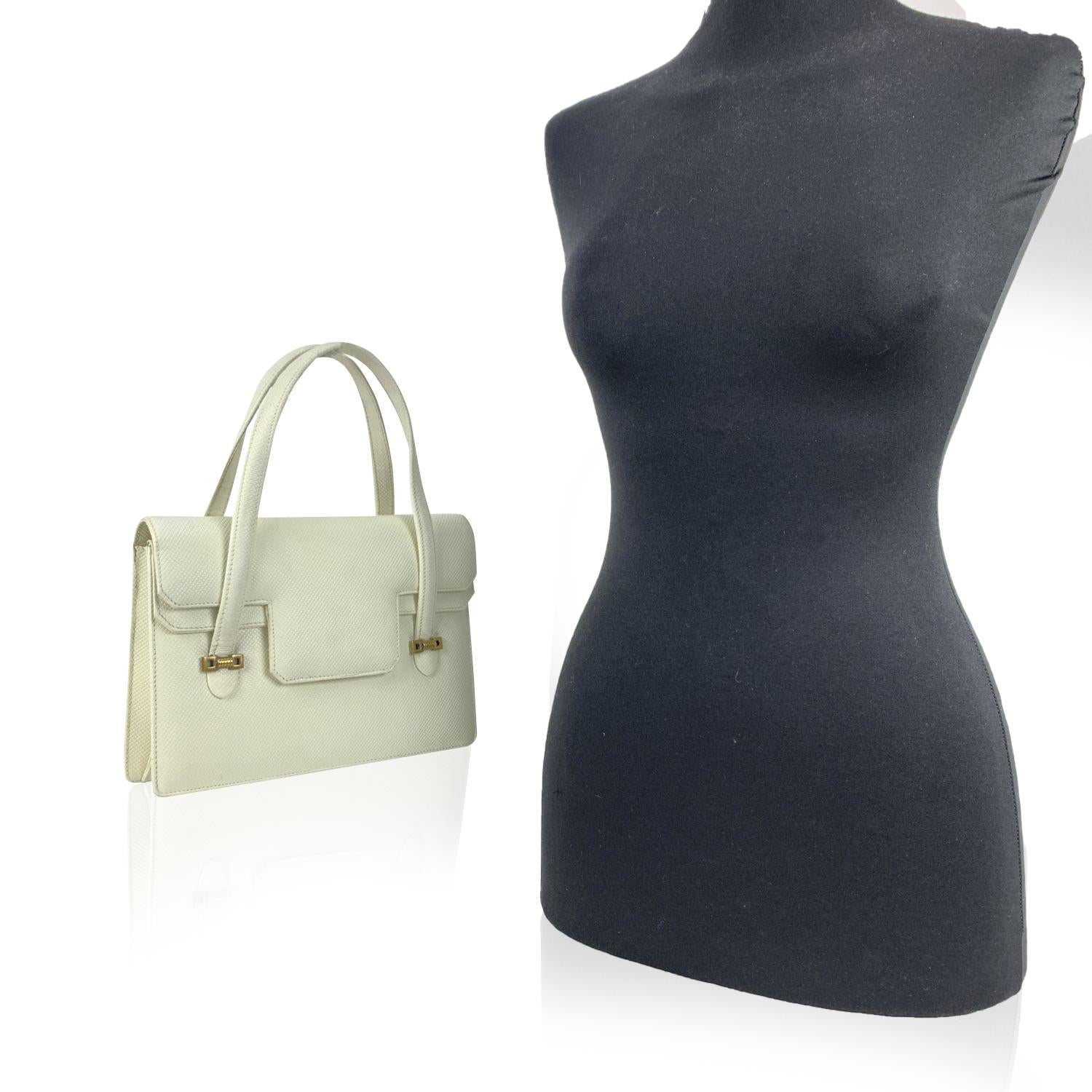 Gucci Vintage handbag. white embossed leather. Gold metal hardware. Flap with button closure on the front. Double flap design. Beige leather lining. 1 side zip pocket and 4 oprn pockets inside. 'Gucci' embossed inside


Details

MATERIAL: