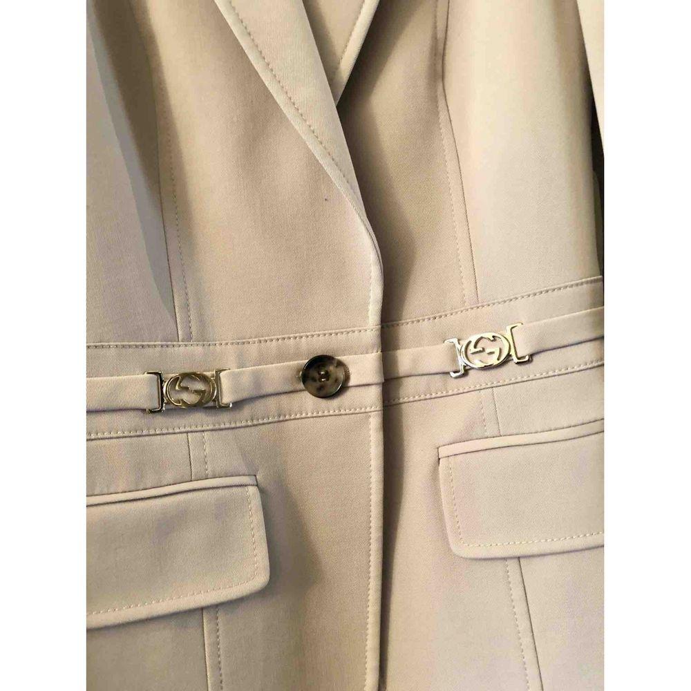 Gucci Vintage Wool Suit Jacket in Beige

Gucci suit jacket and skirt. Golden metallic details and in some places they show signs of aging. 
Padded shoulders, front closure with a button for the jacket and back zipper for the skirt. 
With original